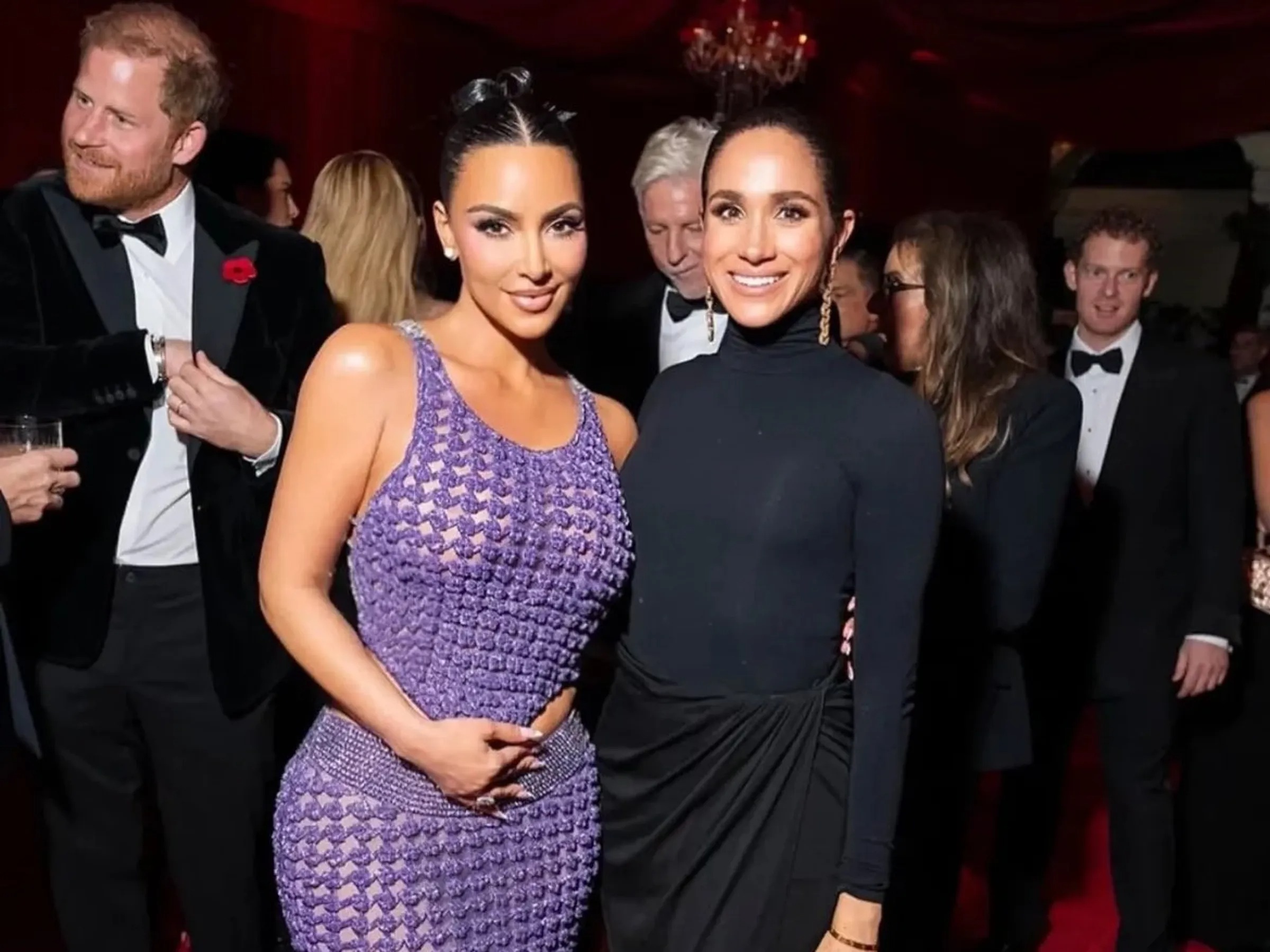 梅根（右）去年11月在派對上與金卡戴珊（中）合照，哈利王子（左）出現在背景中，這張照片已遭刪除。（翻攝kimkardashian IG）
