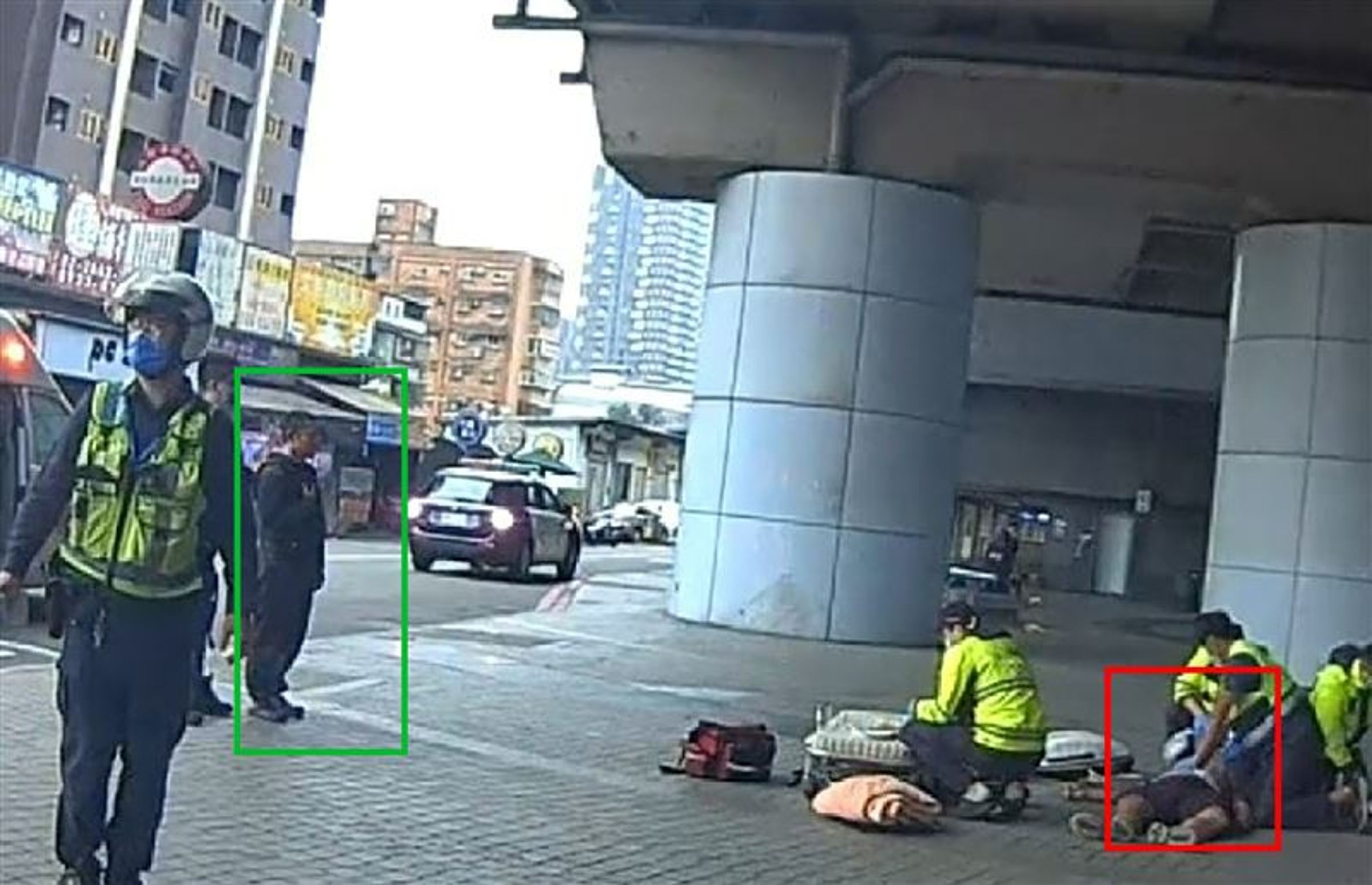 陳瑞祥（綠框）冷血的看著救護人員替林男（紅框）急救。（翻攝畫面）