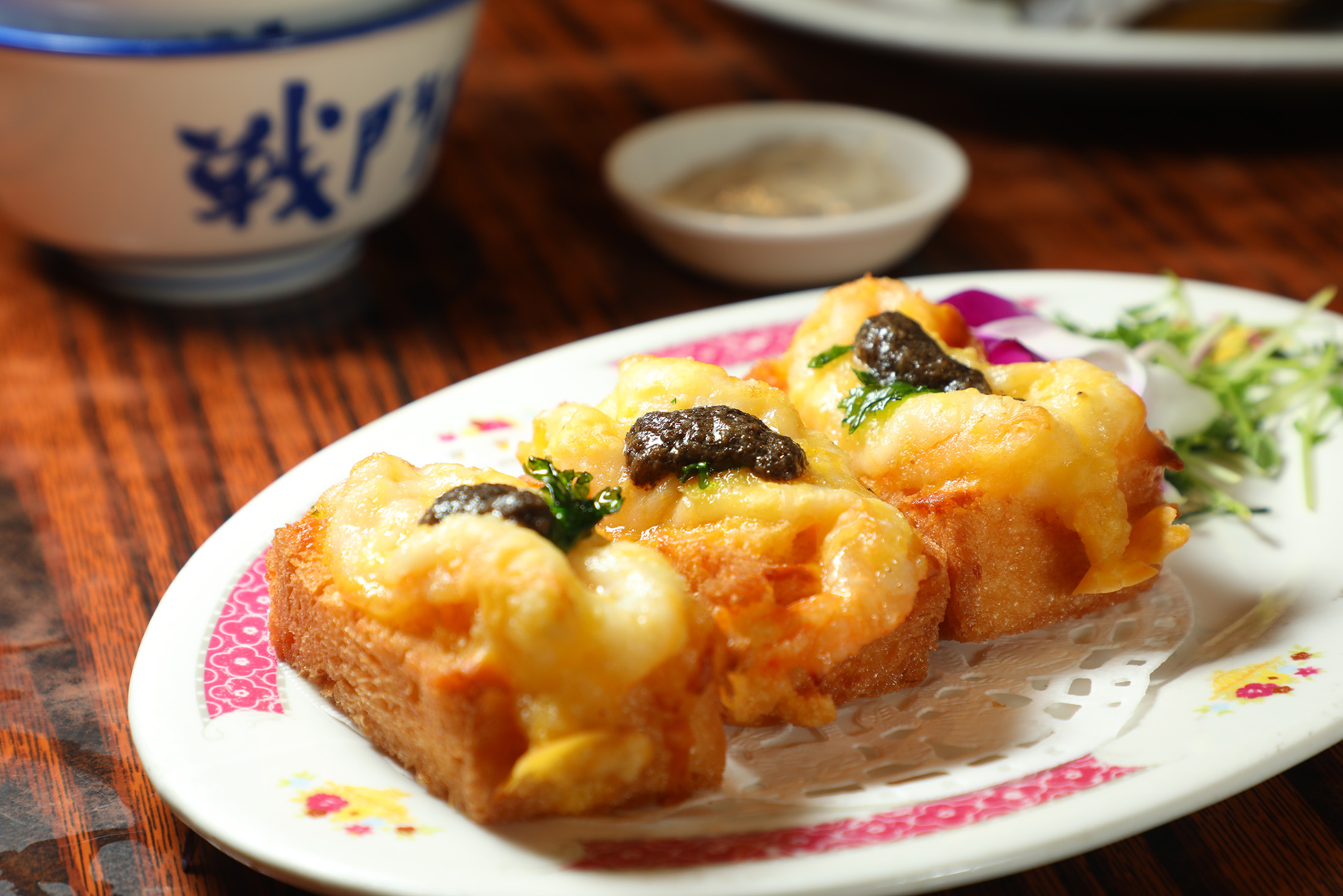 「黑松露厚蝦多士」堪稱是傳統蝦多士升級版，酥脆厚多士鋪上飽滿蝦膠，點綴黑松露醬，一口咬下，舊時味與新潮香交融。（港幣96元／份，約NT$371）