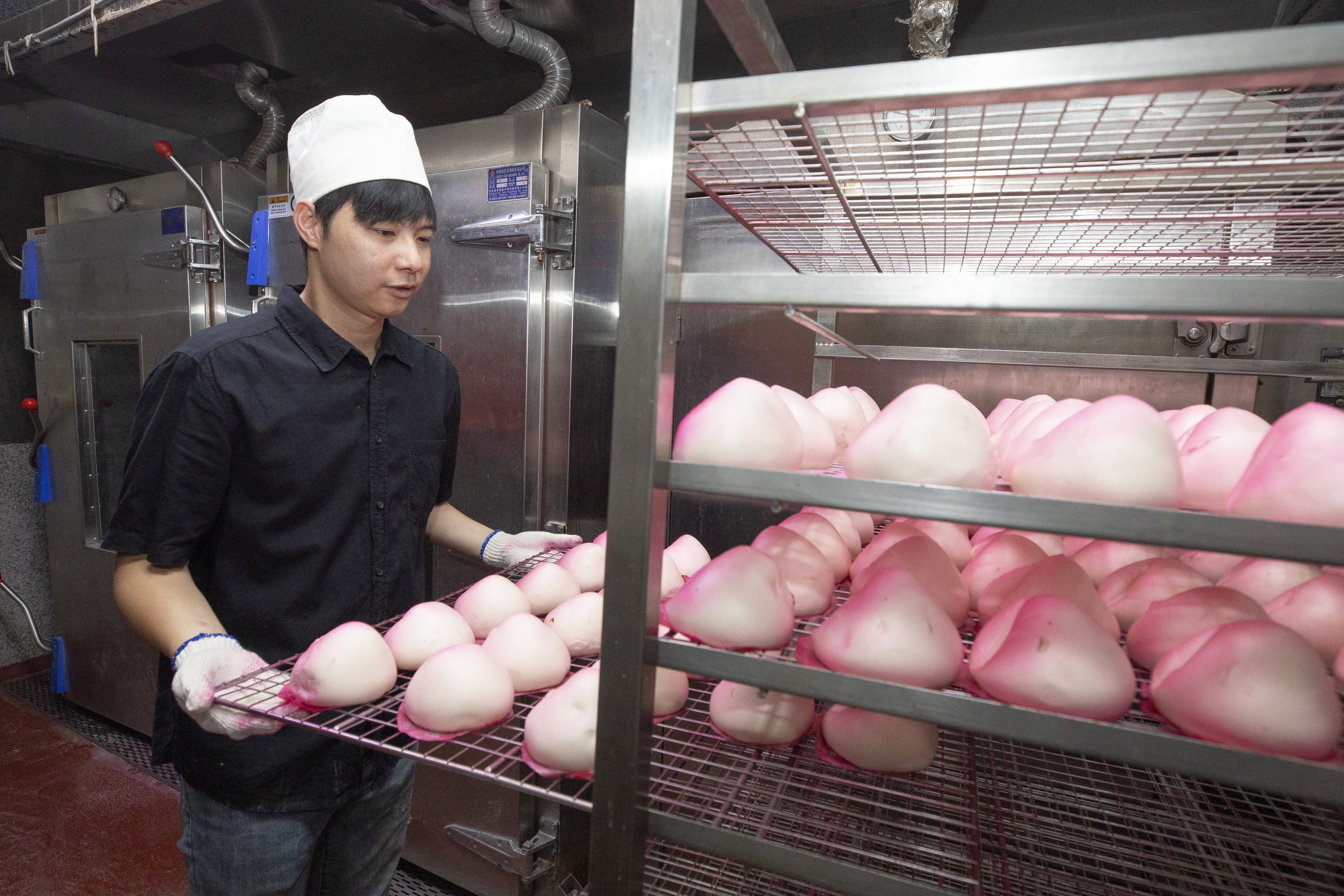 壽桃製作費工，蒸好後需一顆顆壓成桃子造型，再均勻噴色，是十字軒招牌商品。（30元／顆）