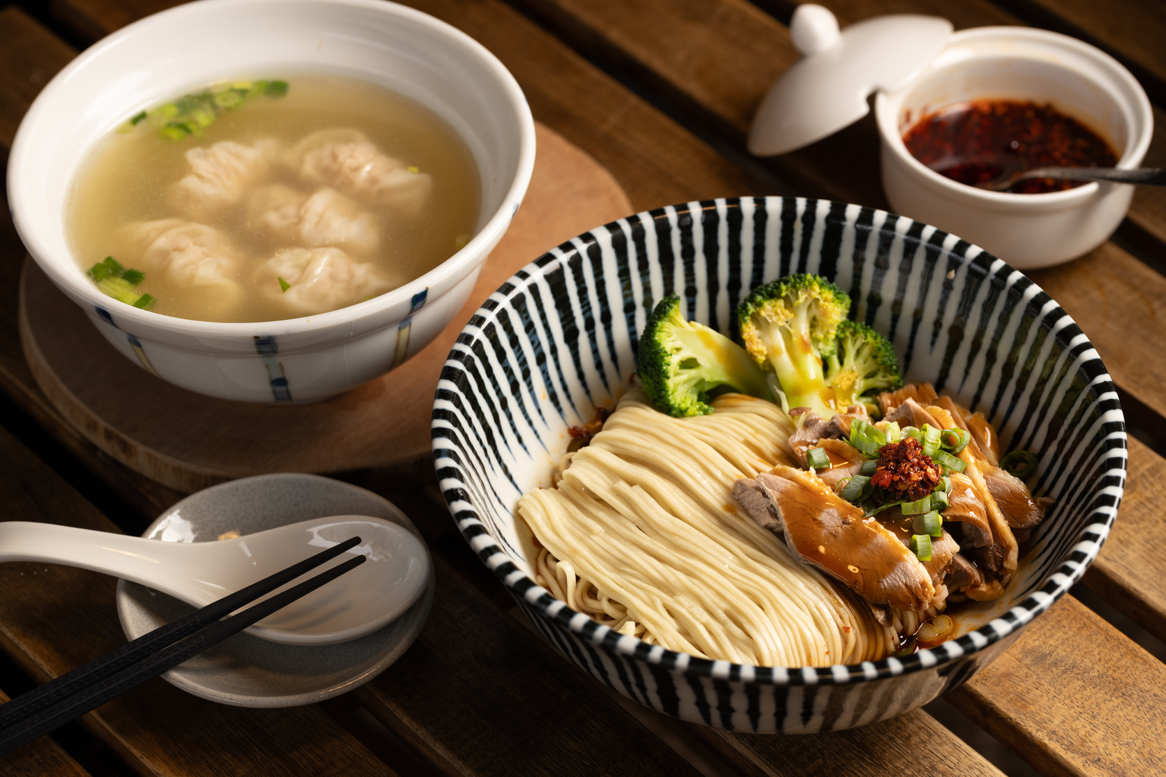 「紅油蒜味鴨肉乾拌麵」（前，80元／碗）特製的紅油醬汁帶有辣度，一口上癮；「餛飩湯」（後，50元／碗）內餡以豆薯代替荸薺，意外增添美味。