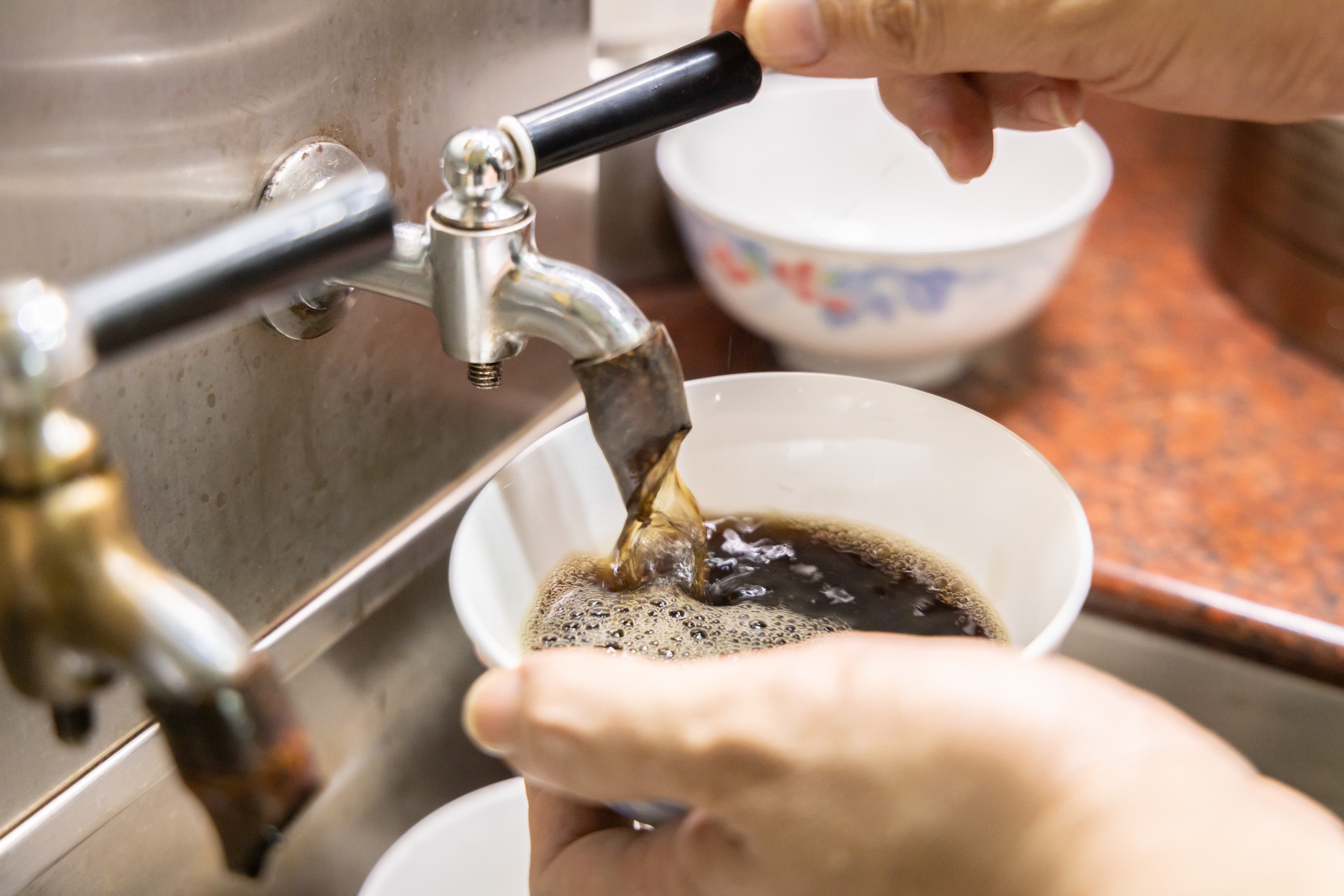 每日早上熬煮好的涼茶，裝在大鐵罐中保溫，打開龍頭就可取用。