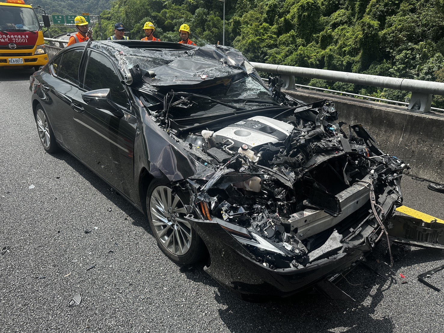 肇事的黑色轎車車頭及天窗幾乎全毀，所幸車內2人無傷。（翻攝畫面）