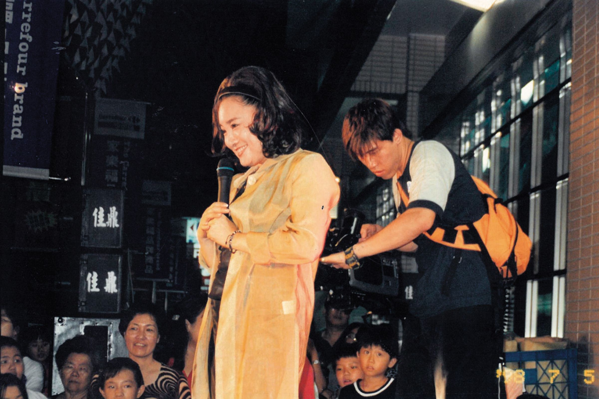 周佑洋（右）任金瓜石活動宣傳時期，陪陳盈潔（左）到夜市辦簽唱會，還身兼側拍師幫旁拍媒體素材。（周佑洋提供）