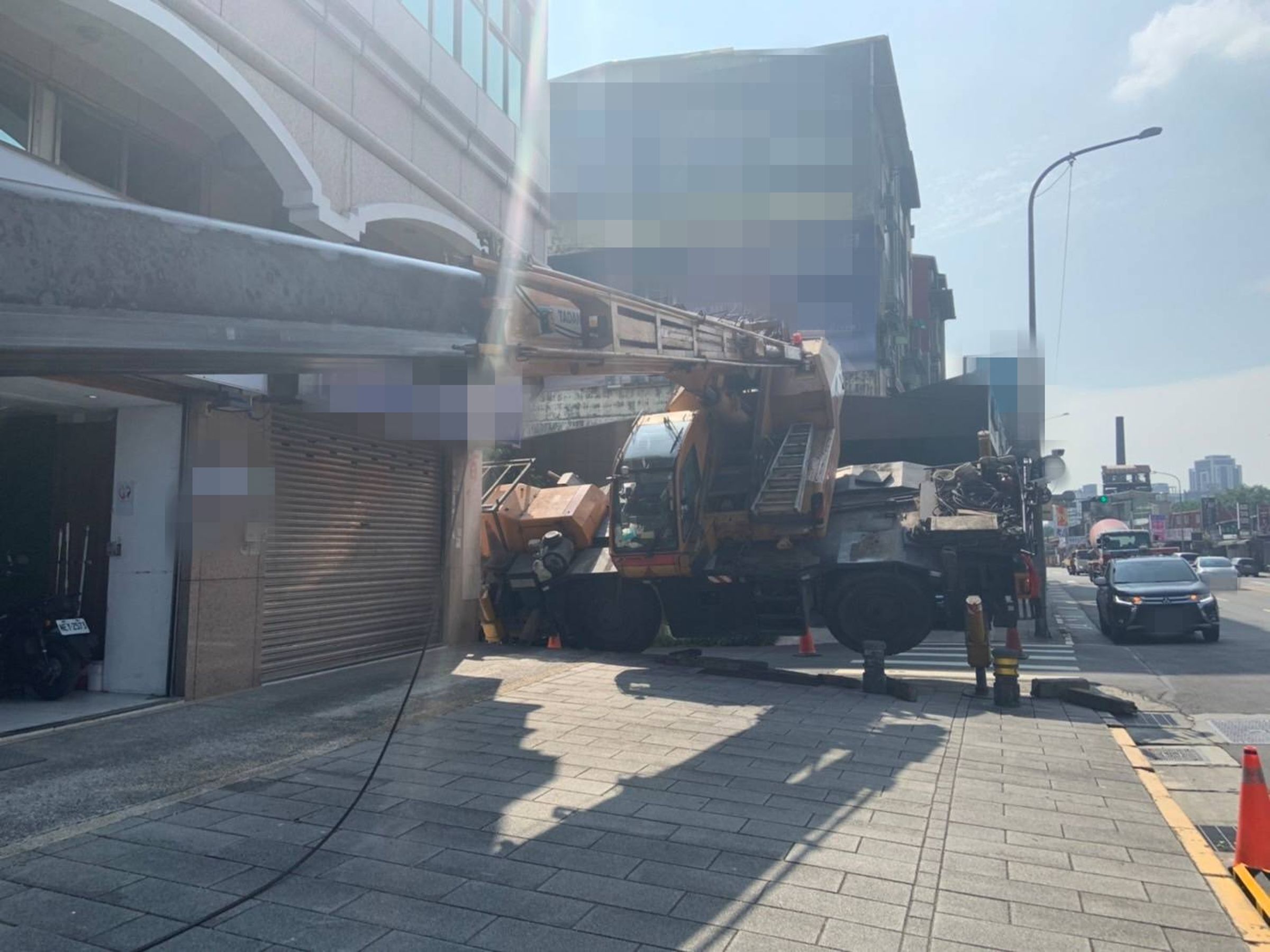 該吊車執行帆布吊掛作業時突然傾斜，僅有吊籠接觸地面。（翻攝畫面）