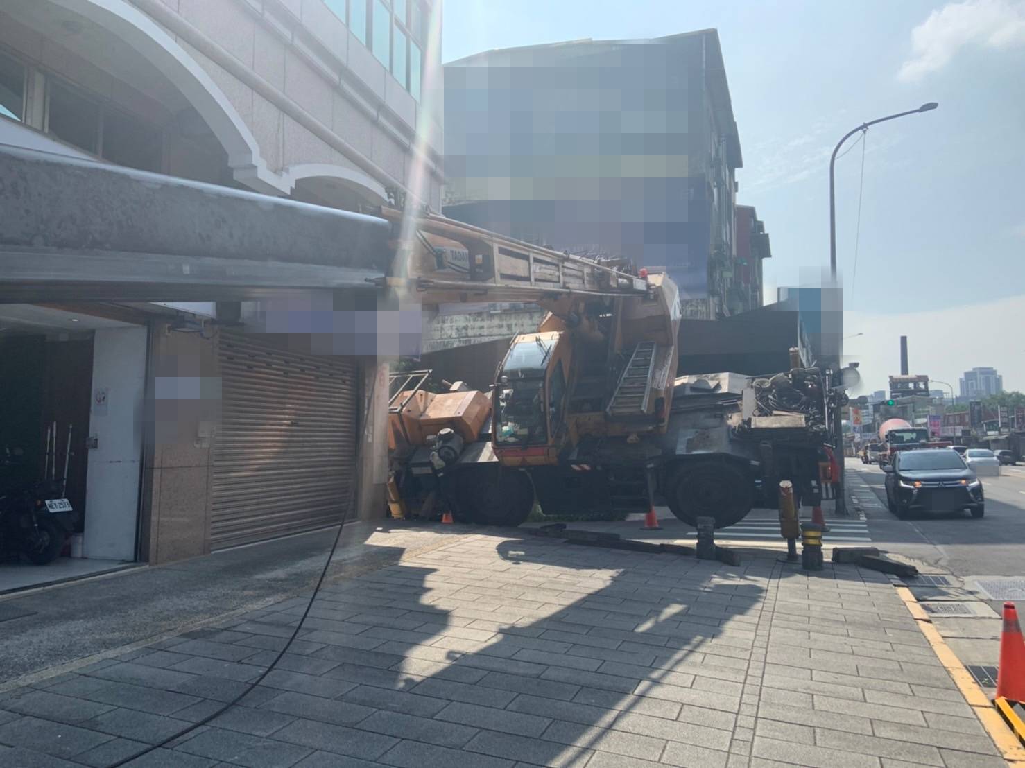 該吊車執行帆布吊掛作業時突然傾斜,僅有吊籠接觸地面。(翻攝畫面)