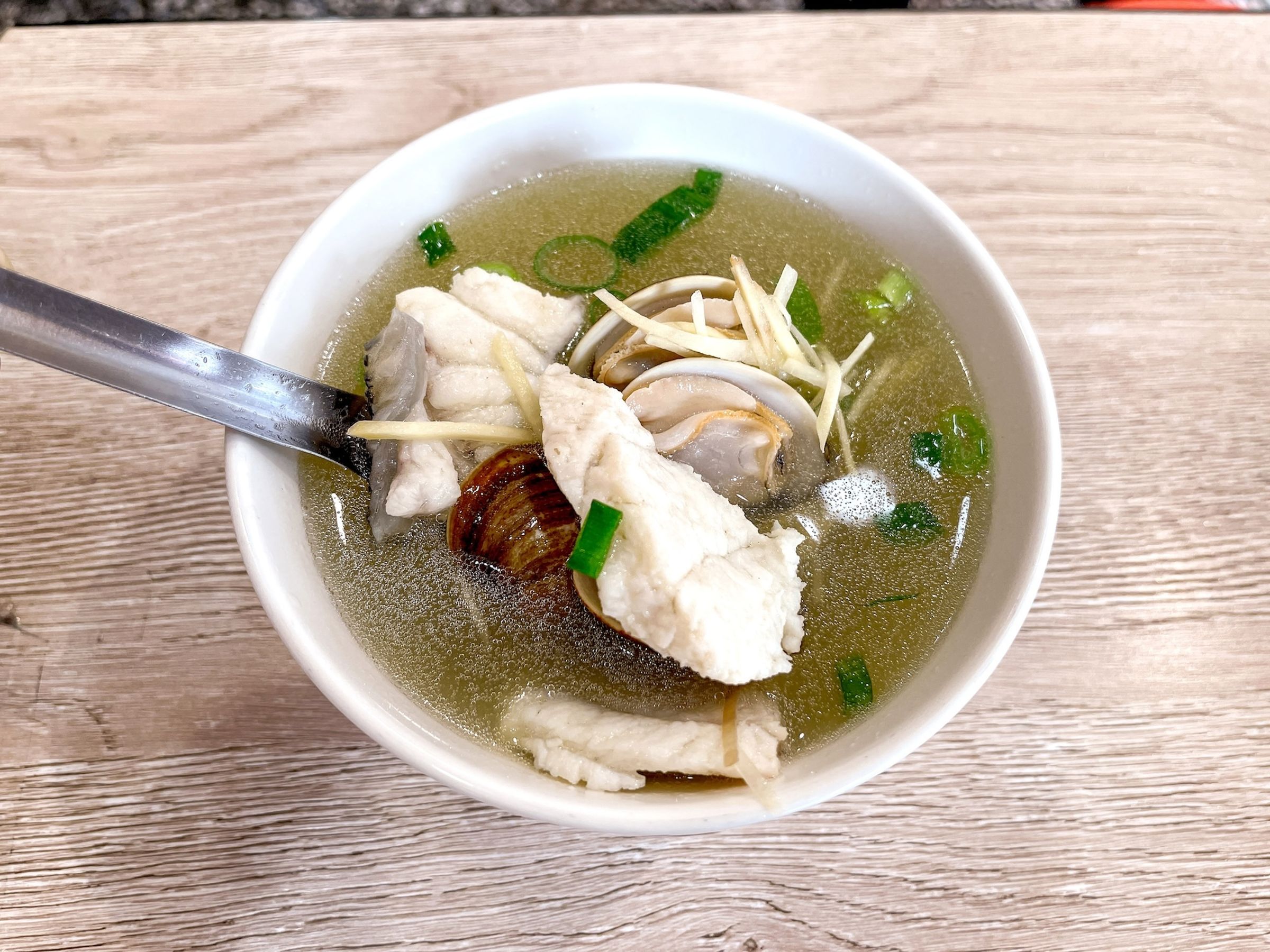 台男「詹記」招牌魚湯以鱸魚骨與蔬菜熬成湯底，再加入蛤蜊及魚片，鮮甜滋味展現魚販第二代對台南在地漁獲的熟悉。（詹記提供）