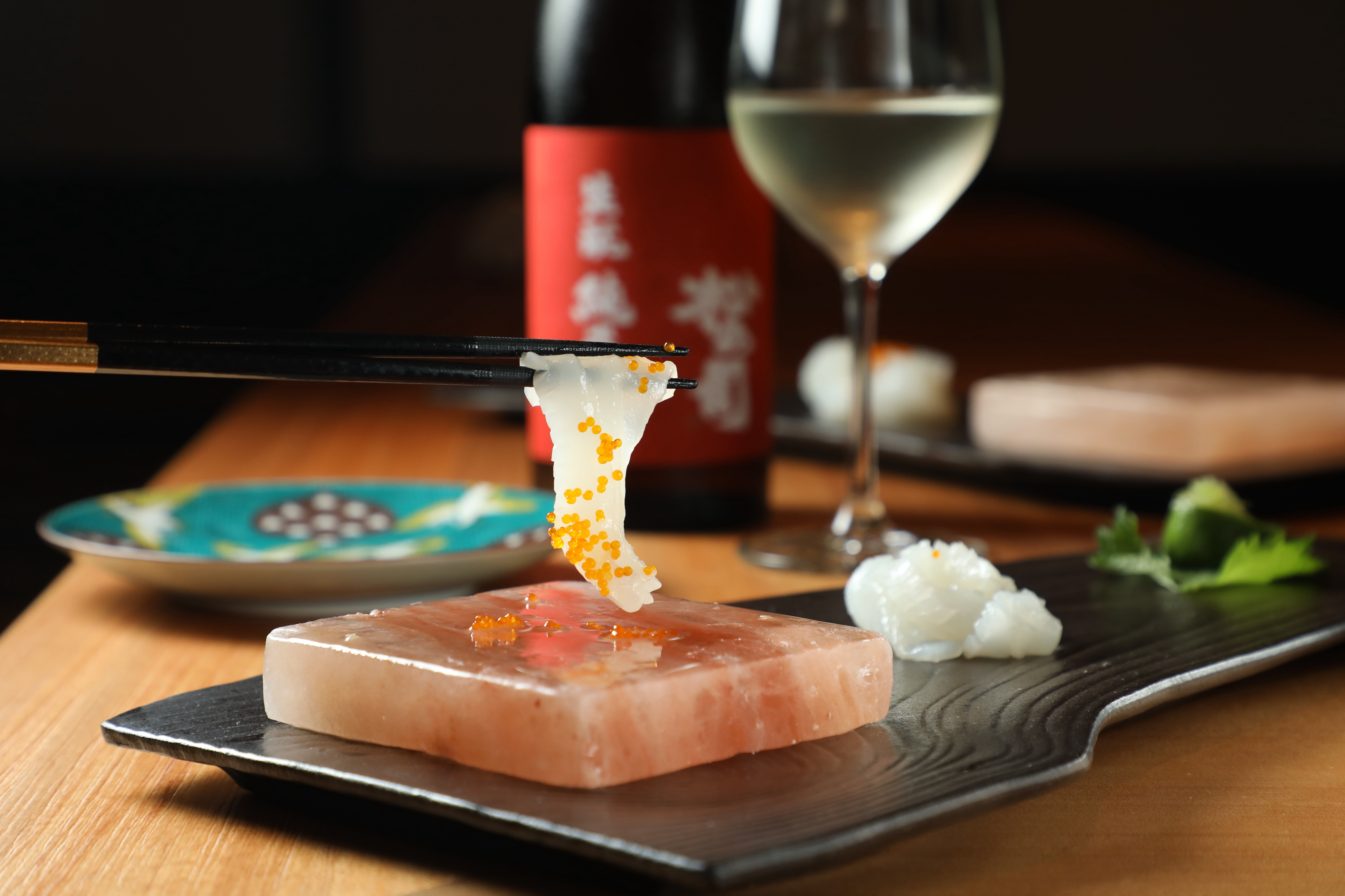 飛翔日料餐廳套餐中的「花枝與飛魚卵刺身」將東港當季花枝切成透光薄片，夾起後在抹過檸檬片的喜馬拉雅岩鹽板上輕涮數次，吃法十分有儀式感。（午、晚間套餐菜色）
