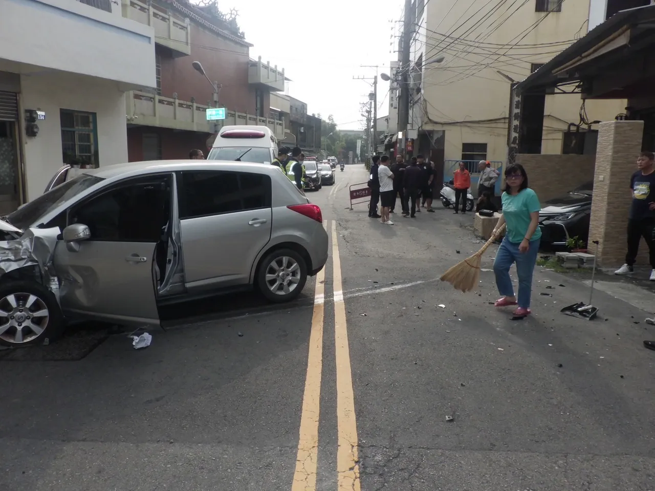 車禍現場一片狼藉，除了遭受波及的車輛殘骸外，還有撞斷噴飛的圍牆磁磚。（翻攝畫面）