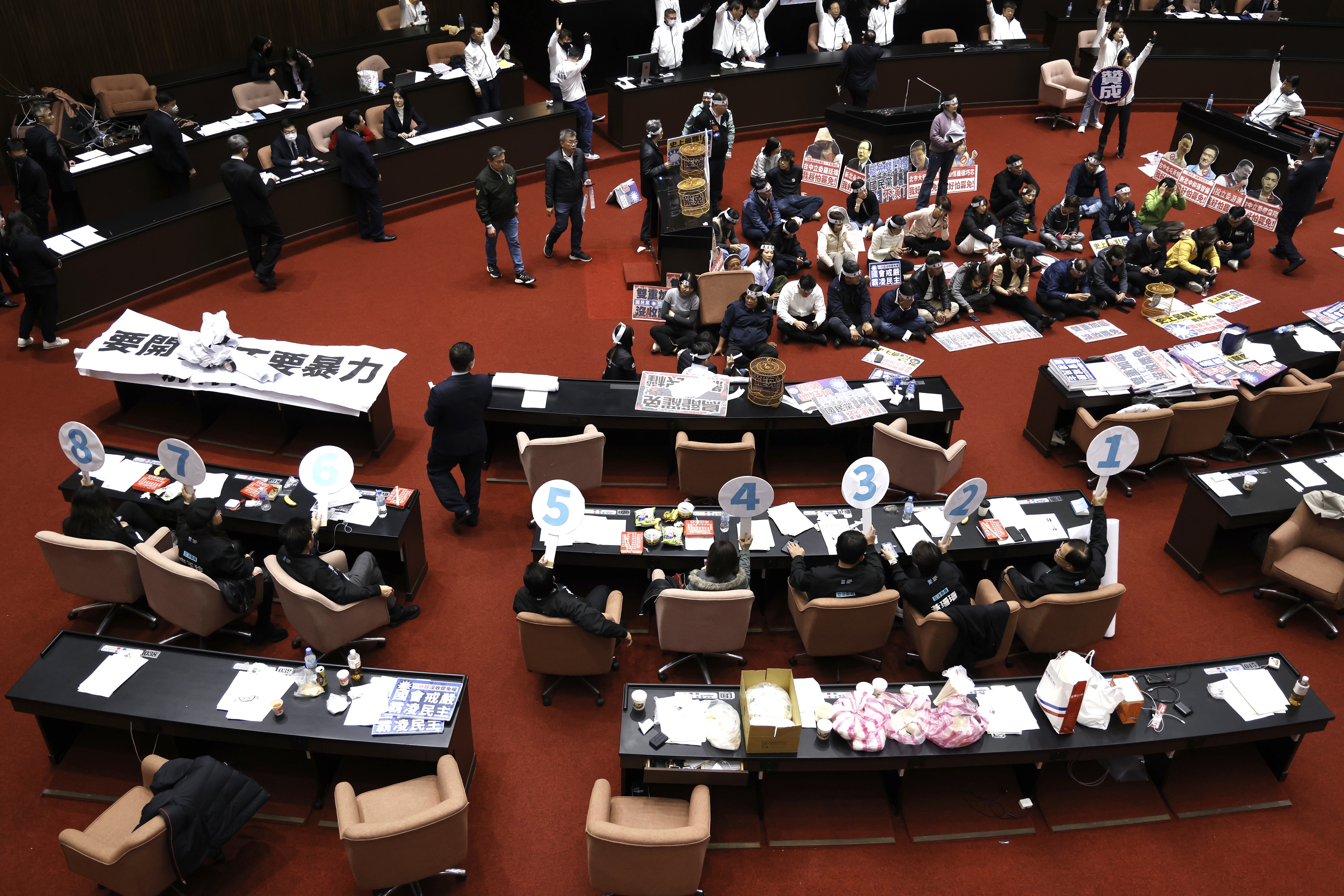 民眾黨8席立委在台下舉牌跟著國民黨團投票。