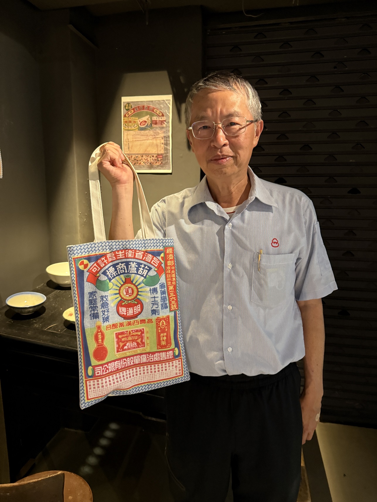 張光發常為住宿旅客們介紹明通製藥發展史,包括繪葉書(postcards)、寄藥包文化以及中藥濃縮機等。圖為寄藥包袋。(張光發提供)