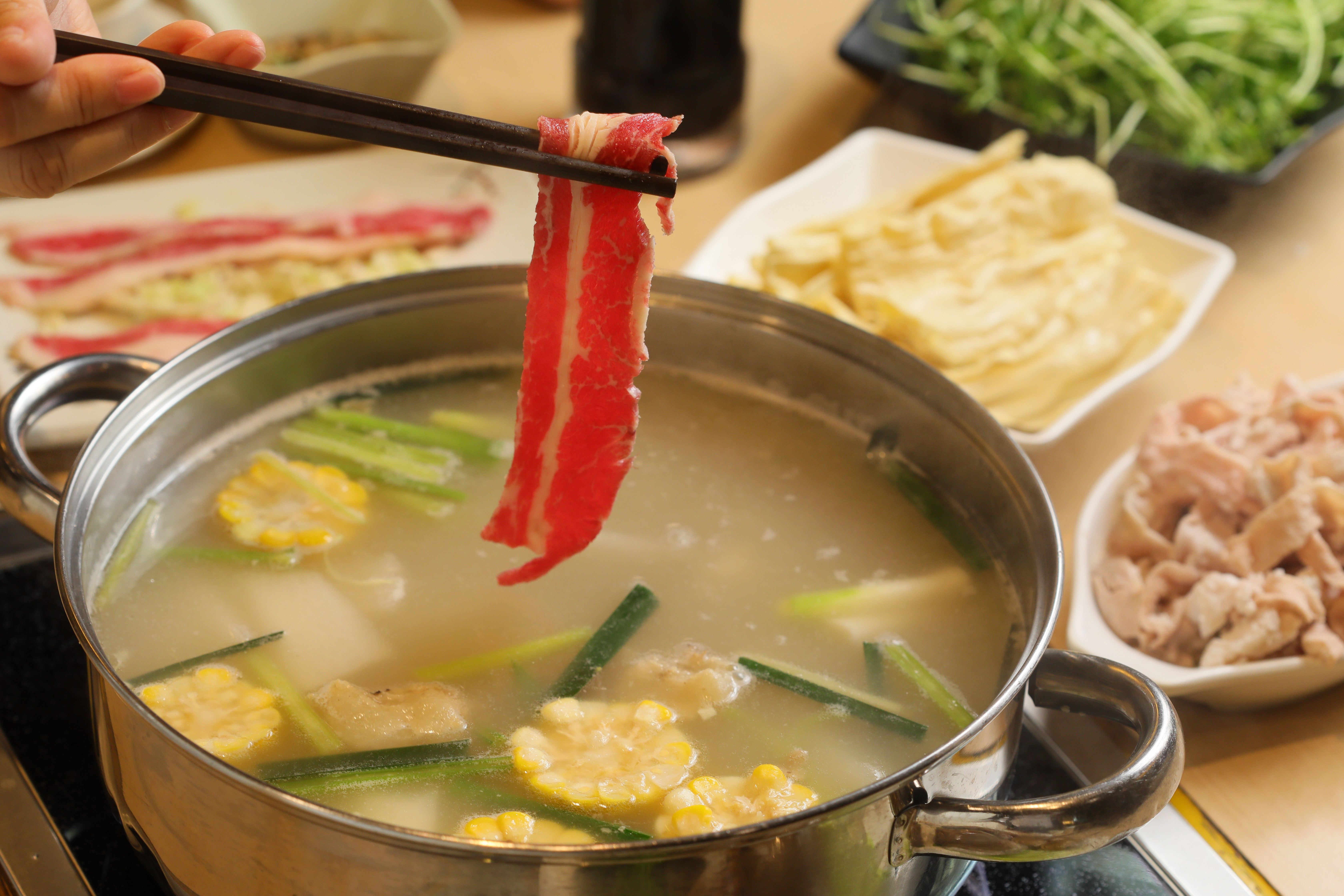 「正宗澳門豬骨煲」湯底滋味濃厚，適合涮燙滋味單純的肉片或蔬菜。（鍋底港幣98元／小份、雪花肥牛港幣40元／份）