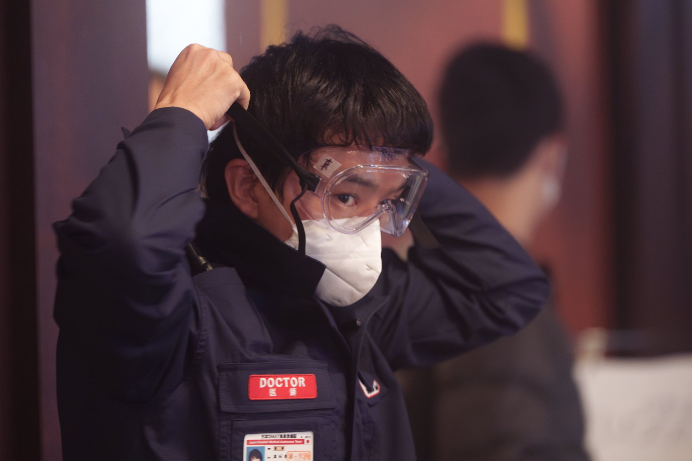 日星池松壯亮在片場堅持長時間佩戴N95口罩,休息時間也不取下。(翻攝《戰疫前線》官方X)