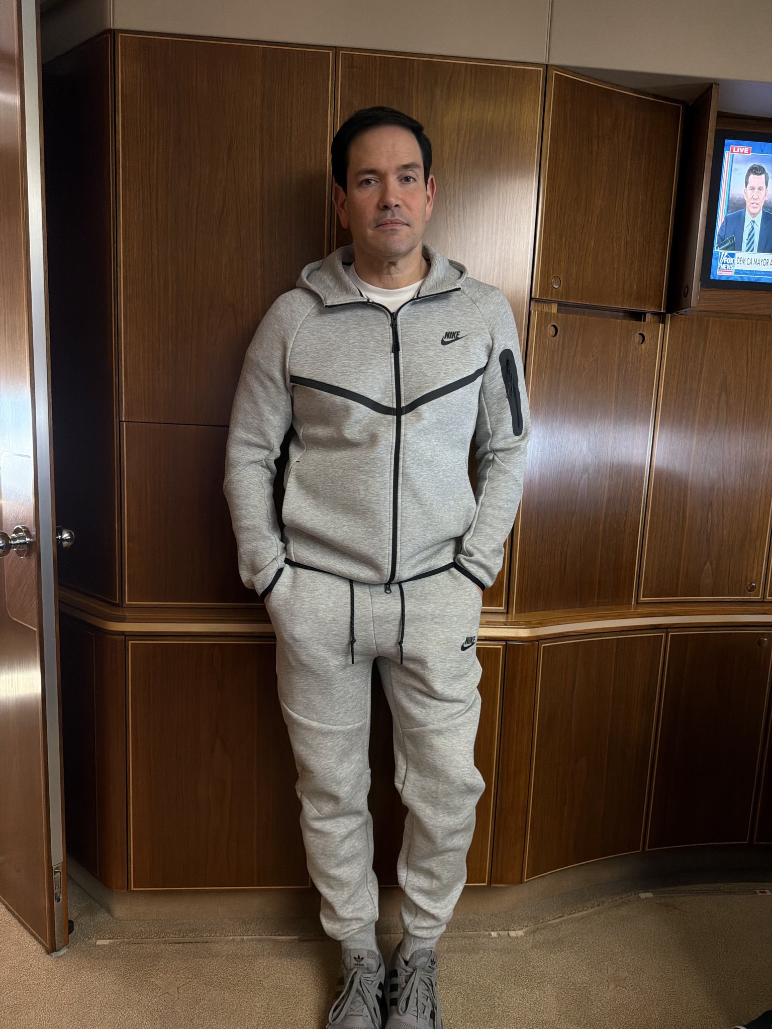 盧比歐一改過去官員出訪時的西裝革履，換上一套極簡的灰色Nike Tech運動套裝。（翻攝自@StevenCheung47 X）