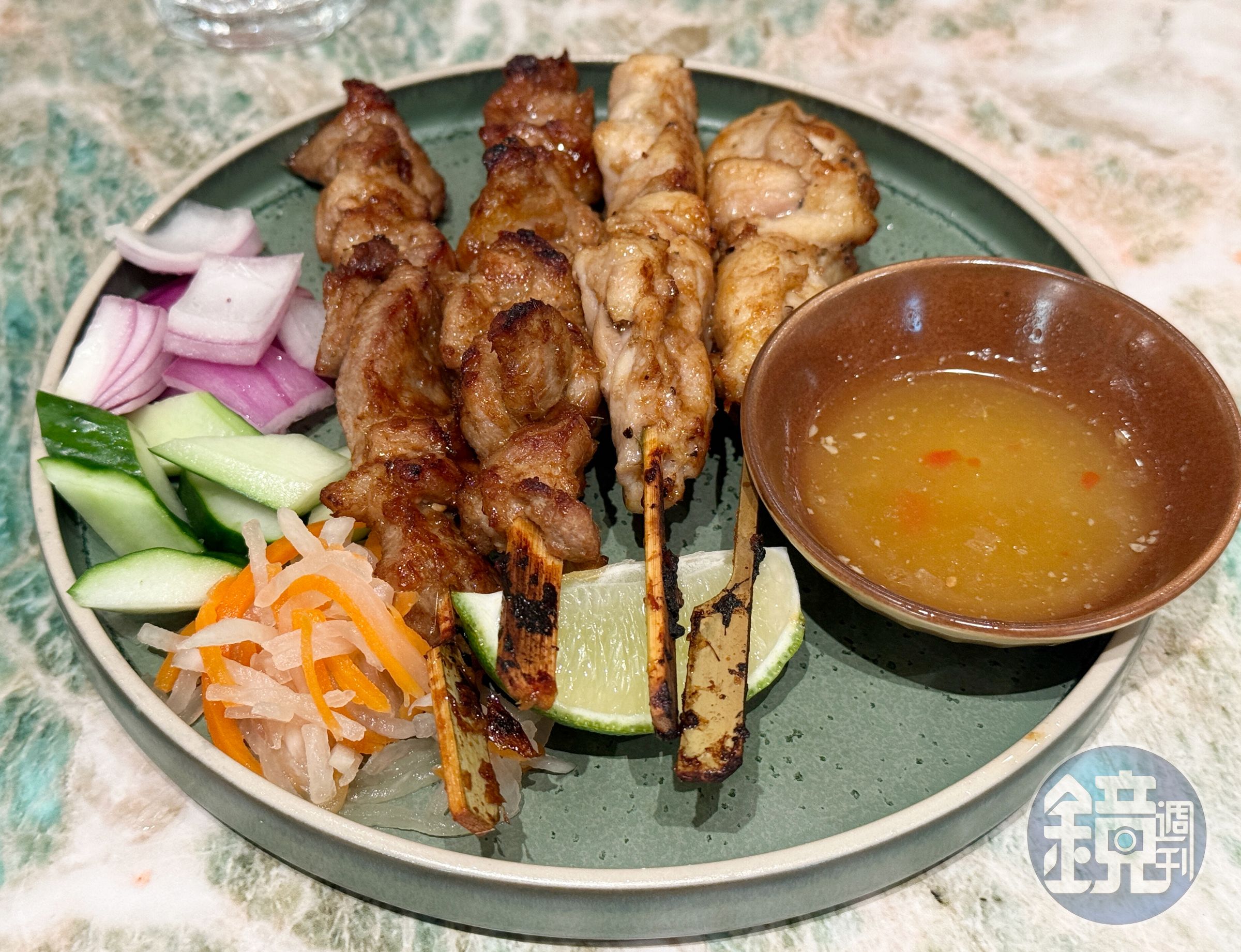 「河內烤肉串拼盤」選用雞腿肉、豬梅花以秘製香料醃漬，燒烤至外層微焦、香氣撲鼻，搭配生菜與百香魚露。（690元／份）
