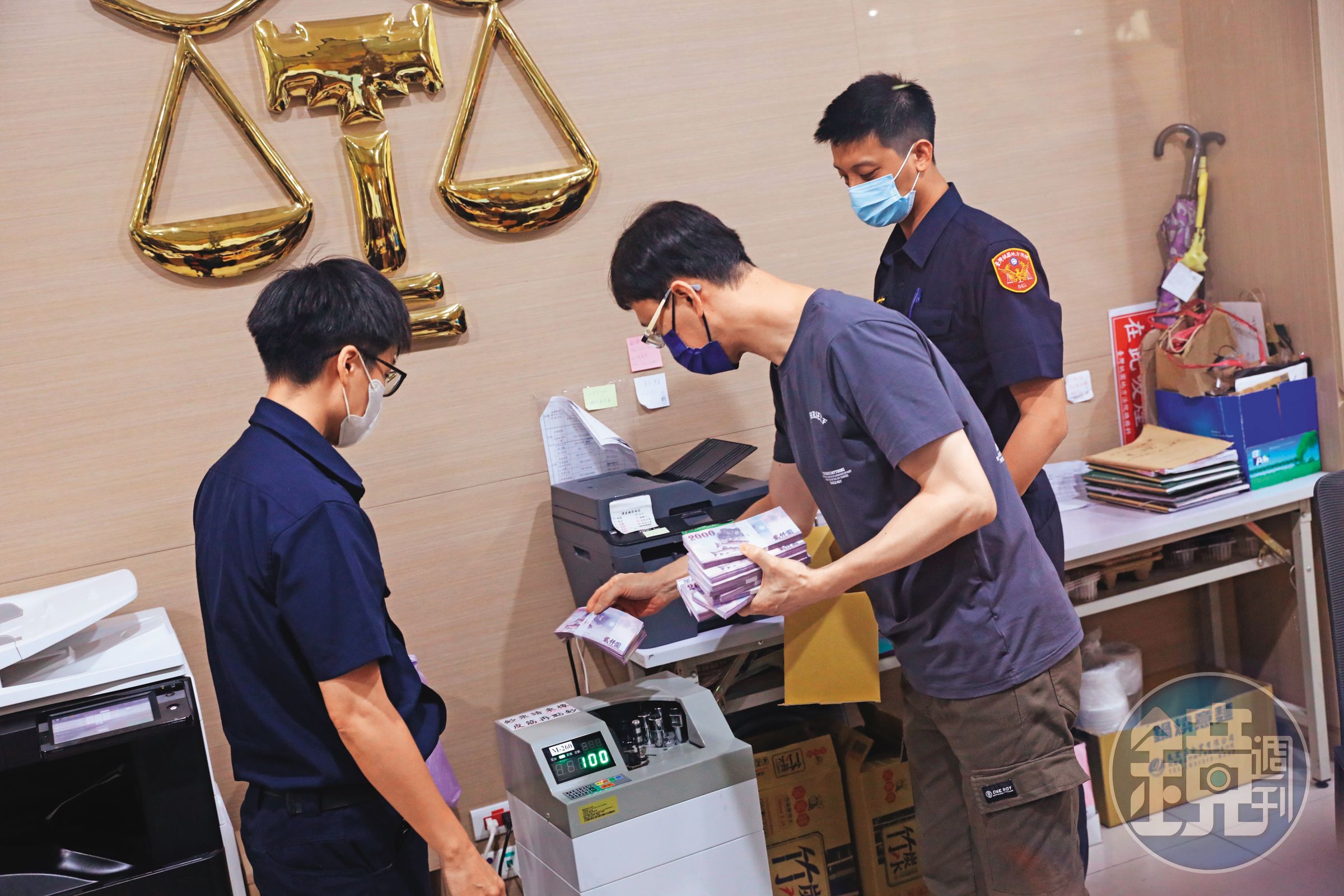 鄭文燦親友帶著500萬元前來法院辦保,由法警戒護協助點鈔作業。