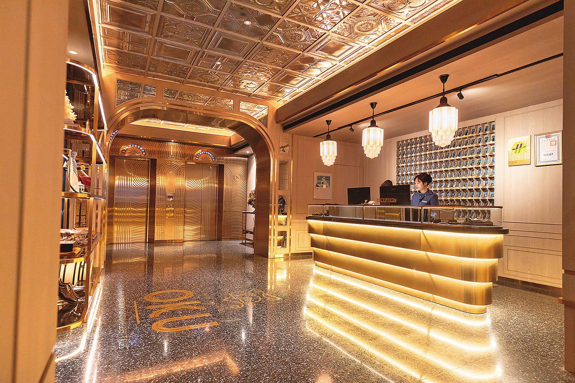 酒店的櫃檯空間讓人宛如走進電影《大亨小傳》的派對場景，金屬、玻璃與光影交錯。