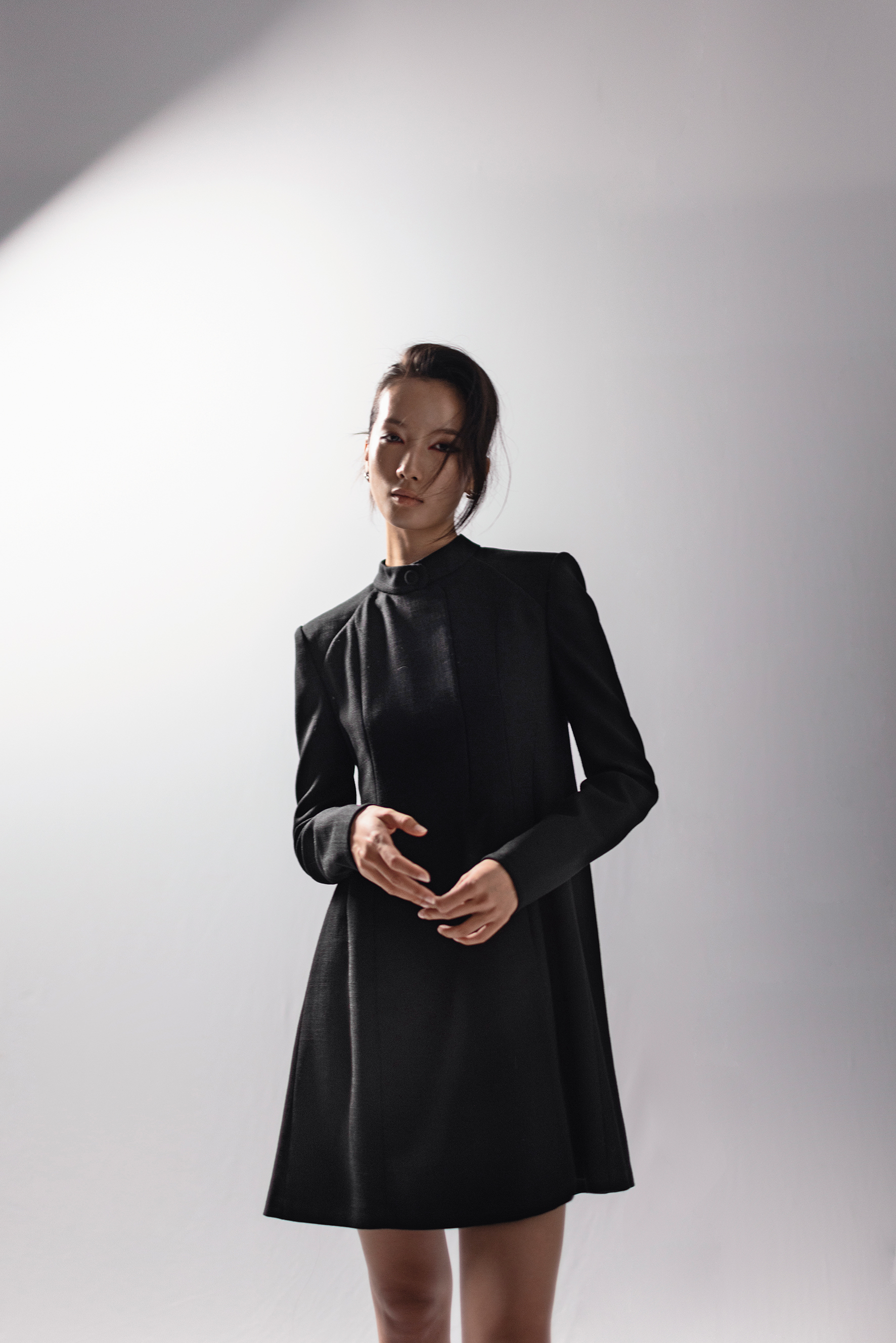 黑色硬挺肩線洋裝，NT$93,400，by FENDI；銀色紐結耳環，NT$23,000，by LOEWE。