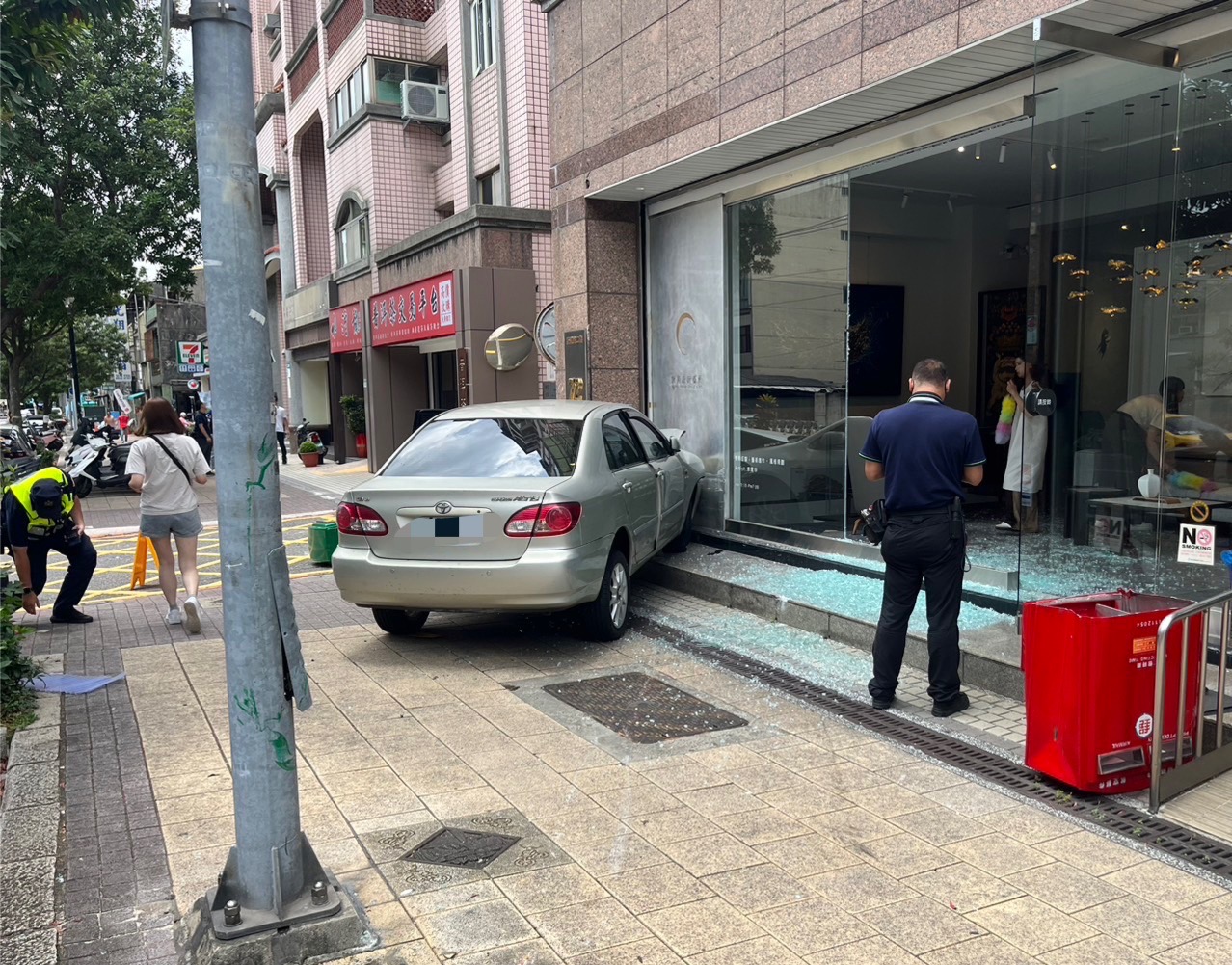 佘男因誤踩油門導致車輛暴衝進一處藝品店，該店落地窗都被撞碎。（翻攝畫面）