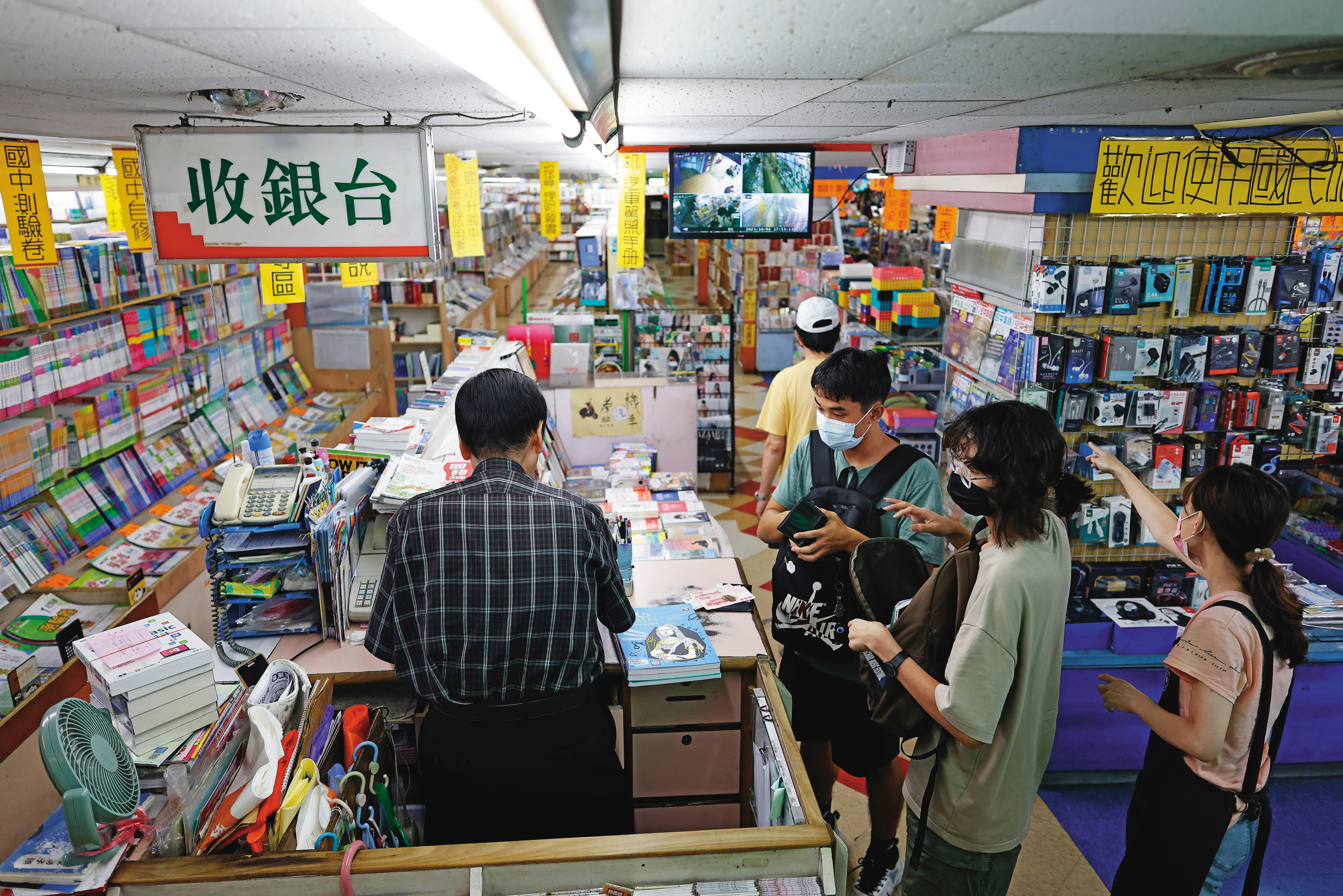 鳳山大書城平日下午客人不斷，幾組是使用文化幣點數放大券的年輕人。老闆張仁飛（左）低調不願上鏡頭。