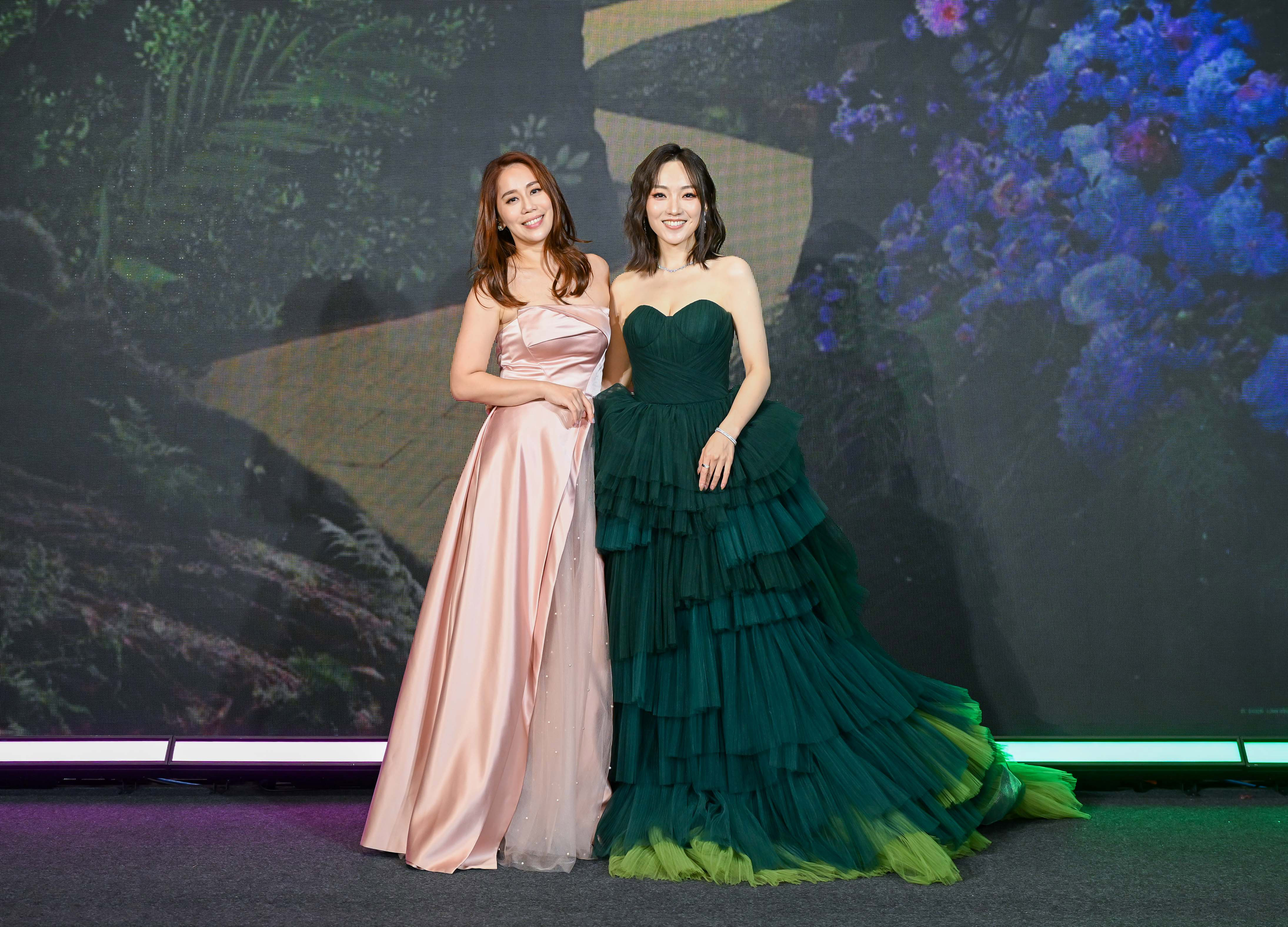 換上粉色系晚禮服，象徵格琳達的劉軒蓁（左），與換上綠色系晚禮服，象徵艾法芭的閻奕格，攜手挑戰《魔法壞女巫》最具代表性的金曲，承認歌曲難度超高，有夠難唱。（UIP提供）