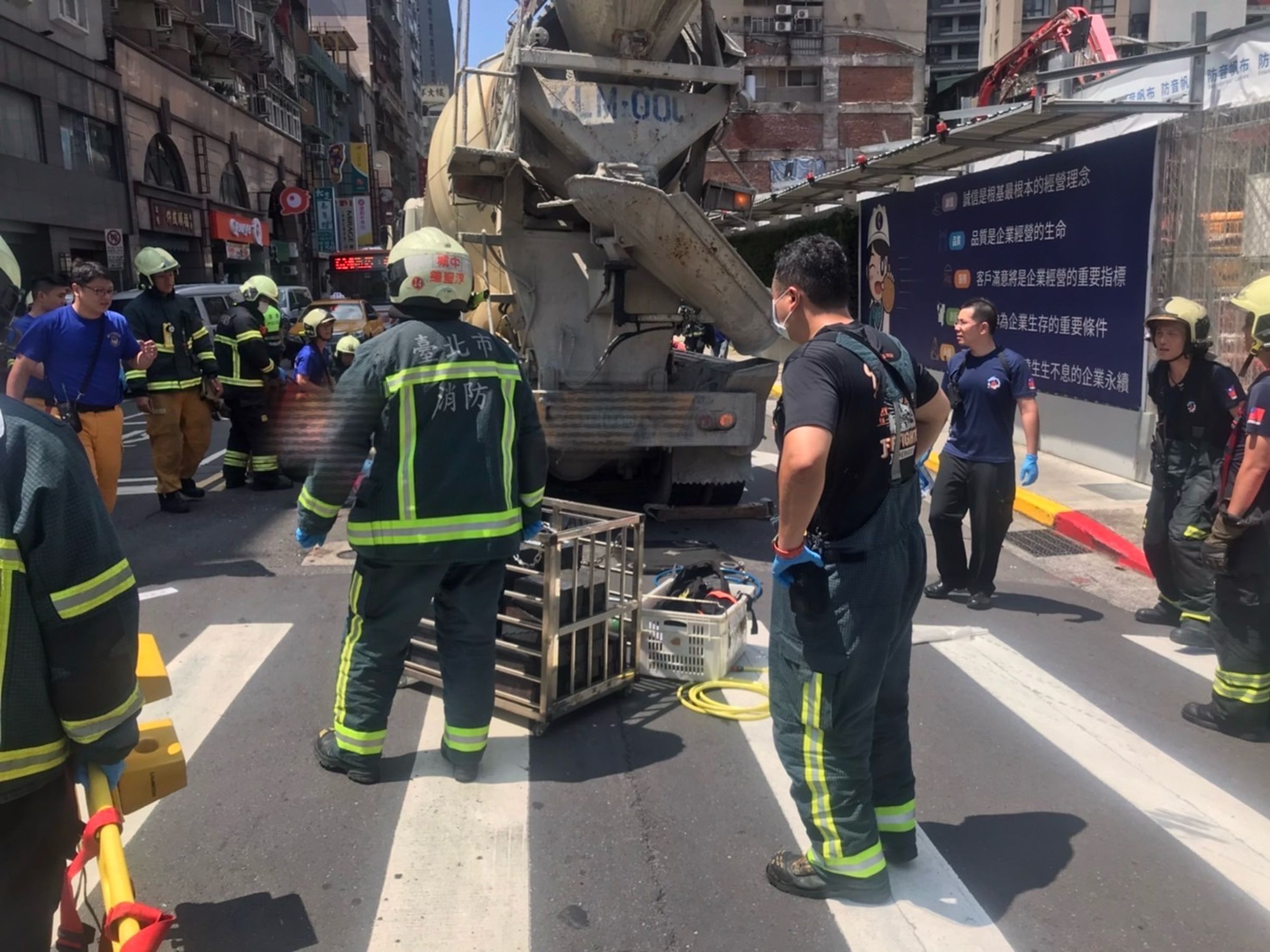 婦人被壓在水泥預拌車輪下，經工程人員卸除水泥後才得以救出困在車底的婦人。（翻攝畫面）
