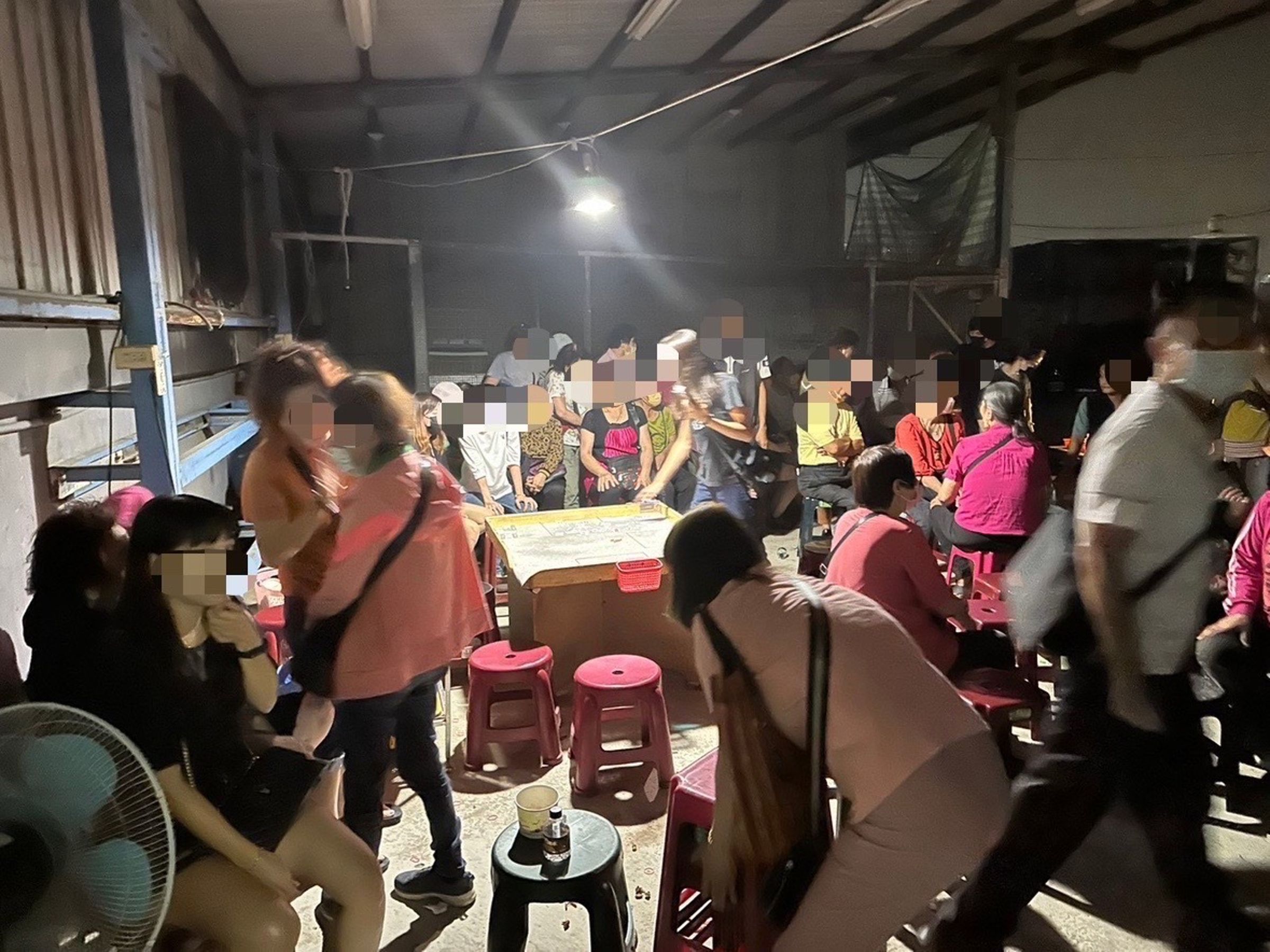 高雄警方於岡山一處鴿舍破獲職業賭場，現場查獲賭場工作人員及賭客等共78人。（翻攝畫面）