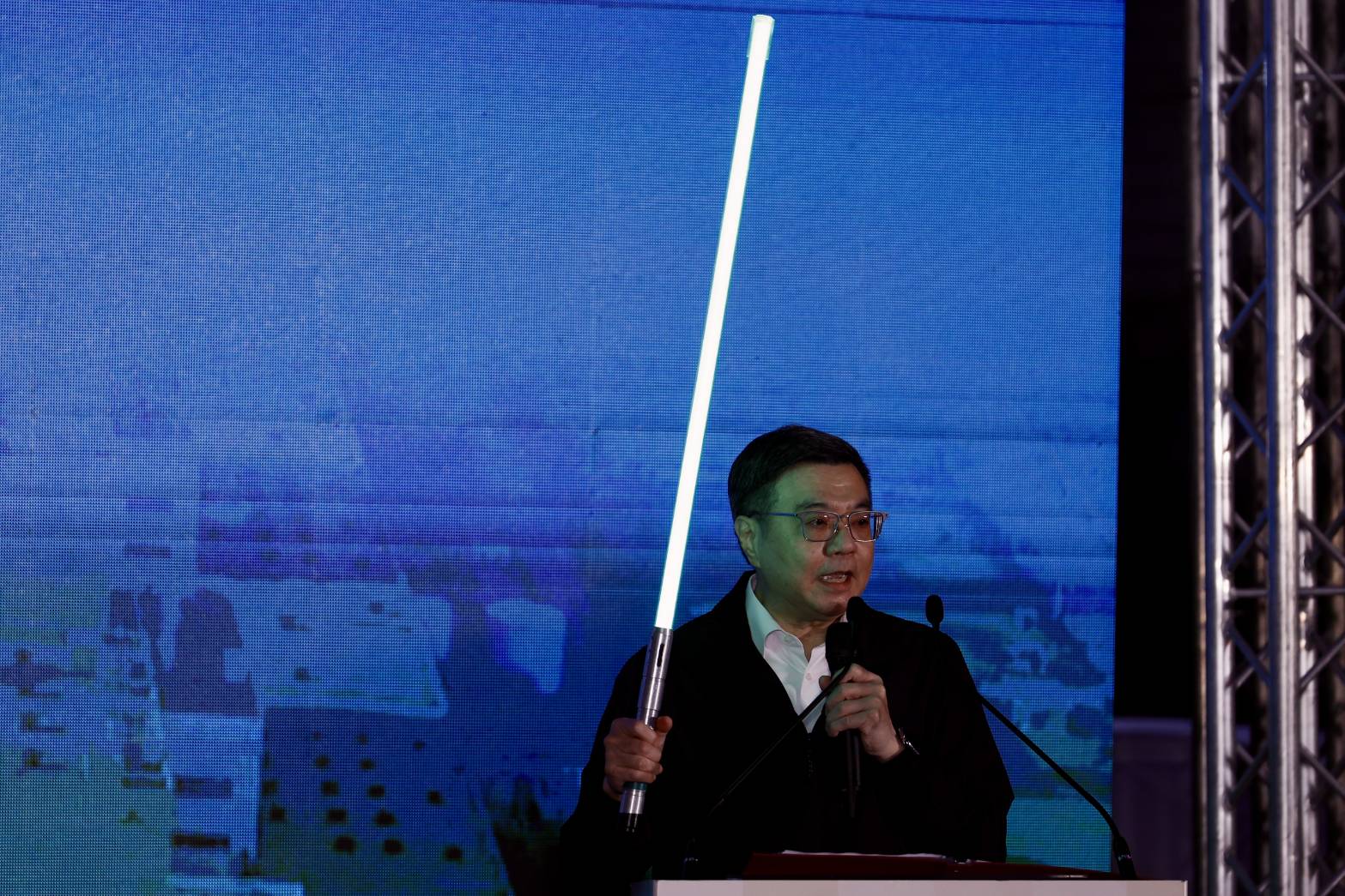 卓榮泰傍晚壓軸登場，宣講約半小時，還拿出「綠色光劍」說明簡報內容，引發現場民眾搶拍。