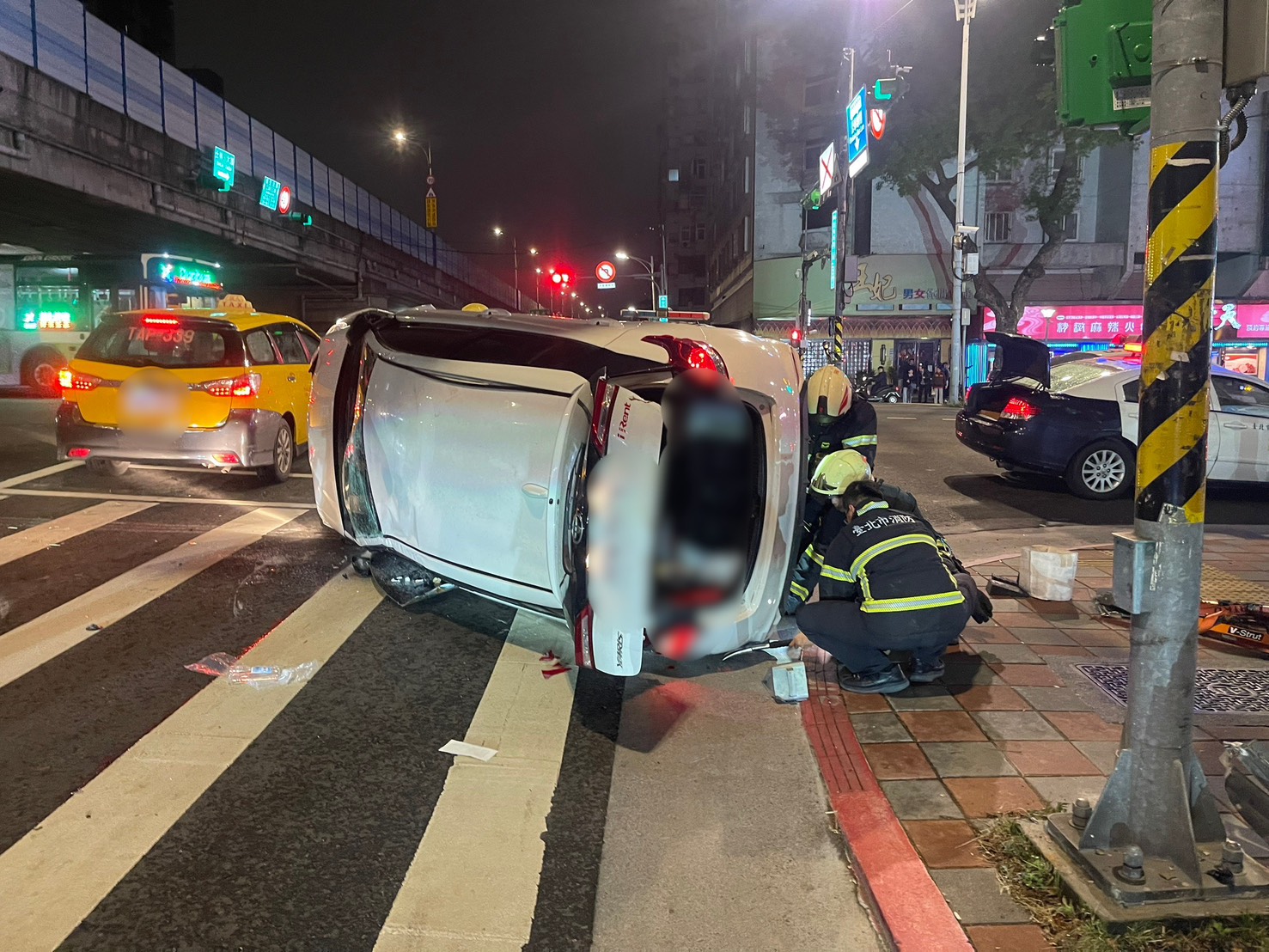 謝姓男子駕駛白色租賃車，在北市新生北路二段發生翻覆，警消到場將受困的謝男救出。（翻攝畫面）