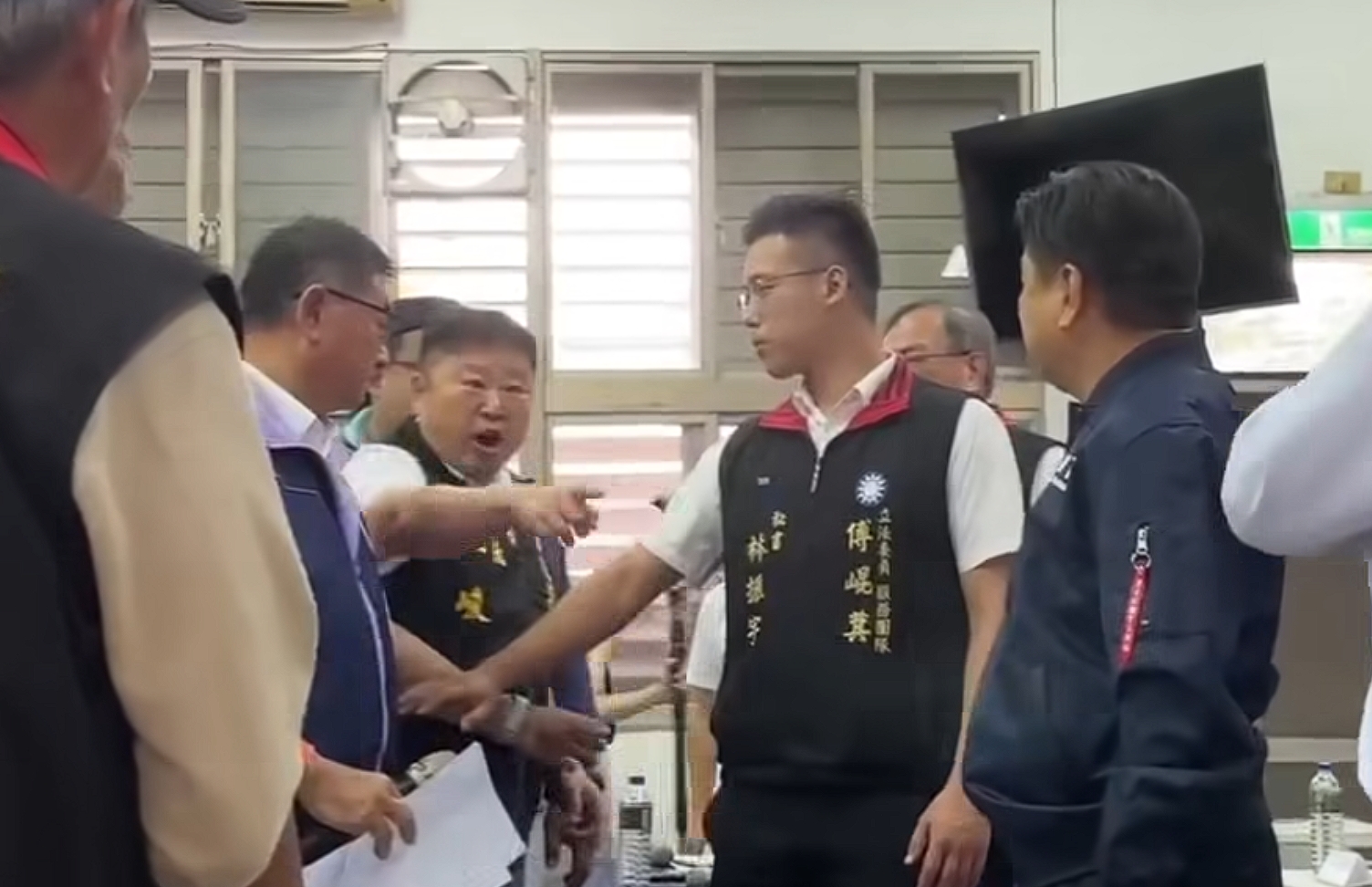 張峻不滿被擋在門外，闖入會場怒踹桌傅崐萁抗議。（翻攝臉書「貓與邪佞的手指」）