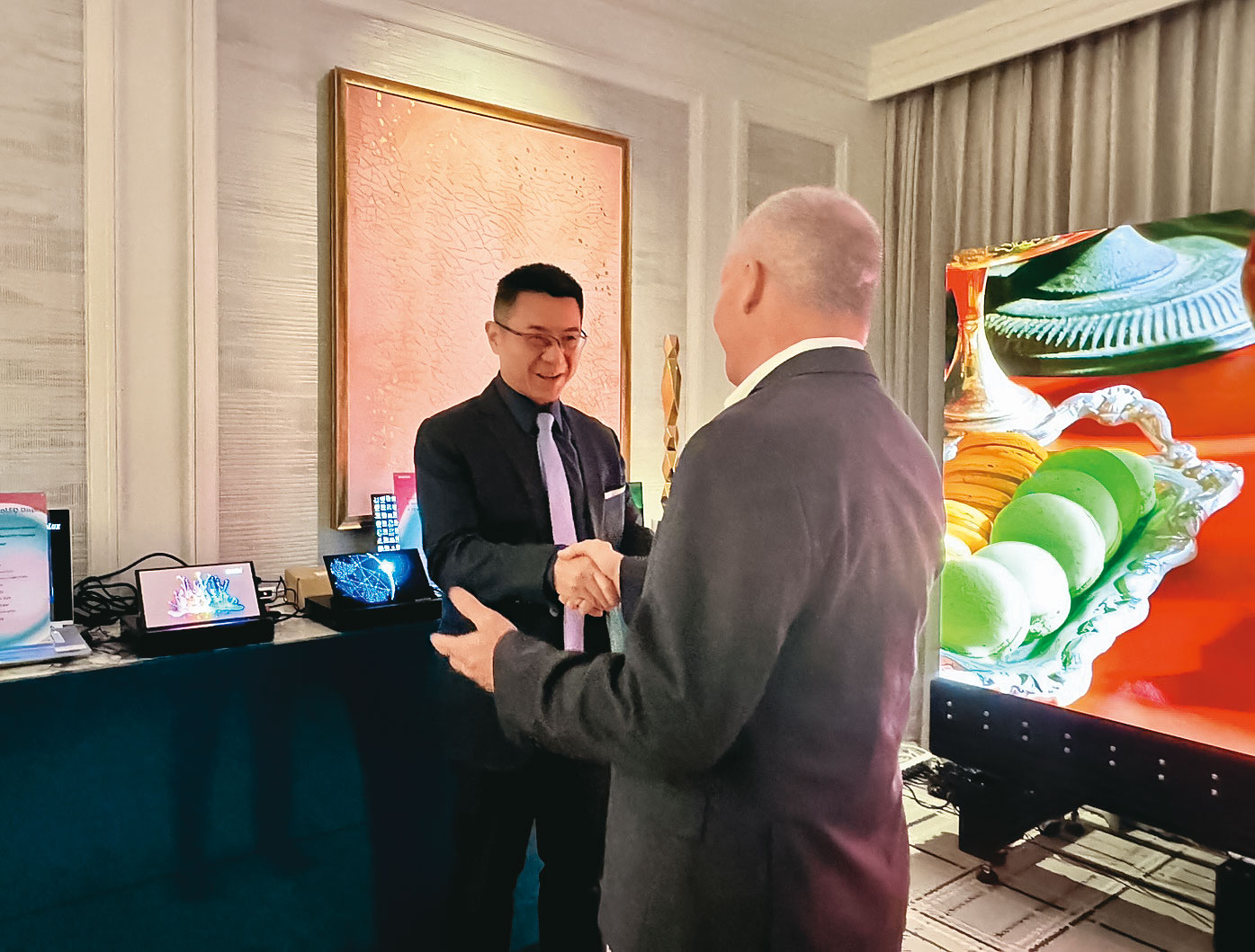 洪進揚（左）在CES見的許多投資人，對群創過去6年的投資報酬率印象深刻。（群創提供）