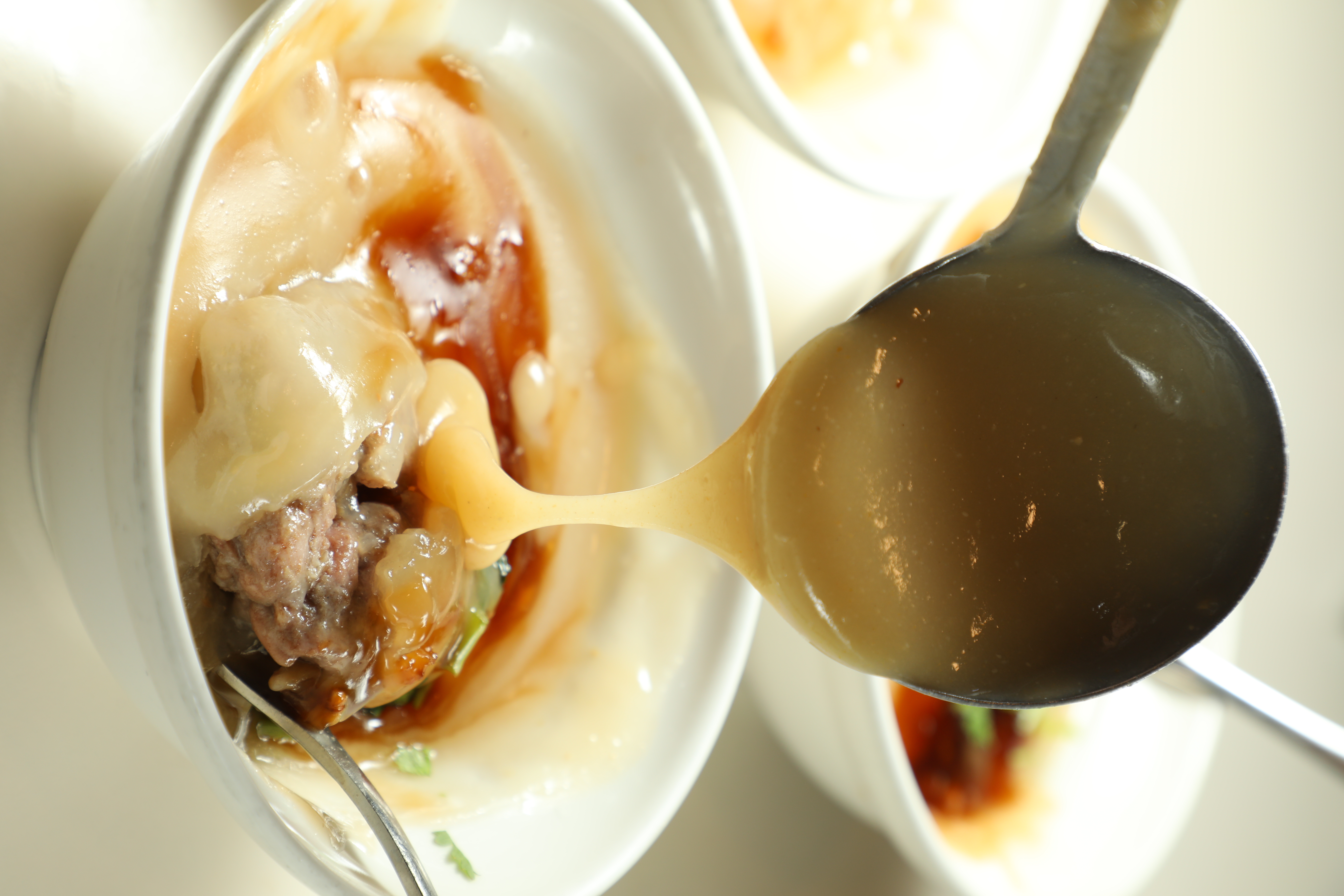 肉圓上淋了黑白醬，黑色是醬油膏，白色是米醬，另外，桌上還有一個看起來像白醬的辣椒醬，辣度超級高，嗜辣者一定要加。