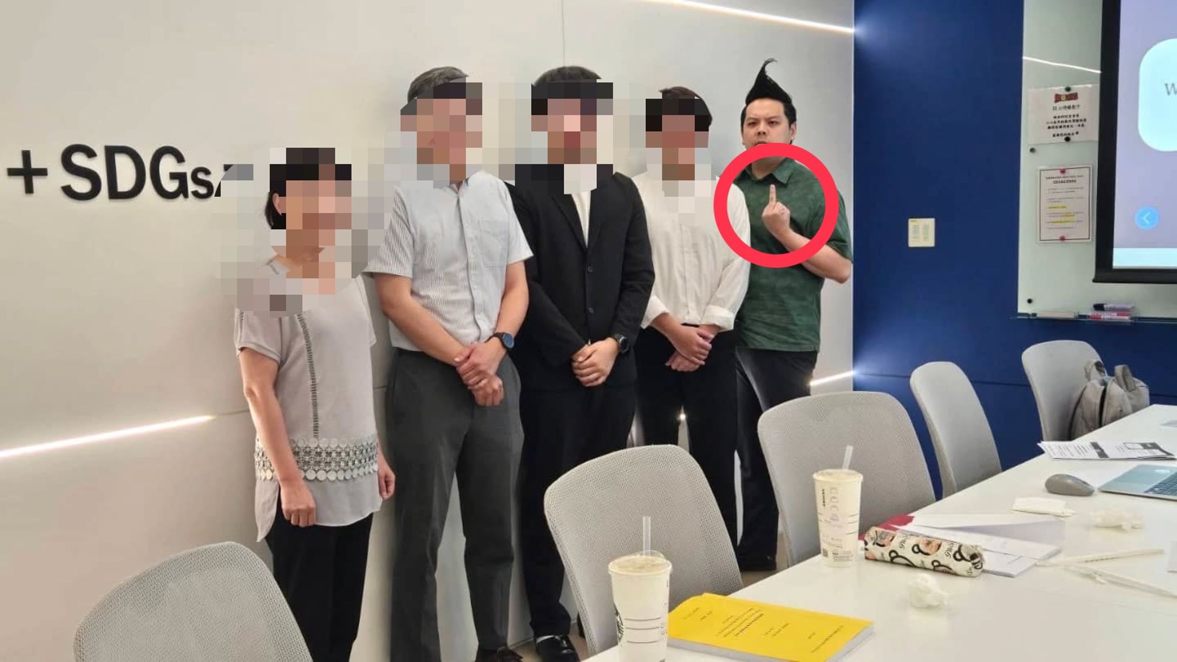 張曾與口試結束的學生合照，卻在拍照時比出中指，對比其他人莊重的模樣，十分突兀。（翻攝自當事人臉書）