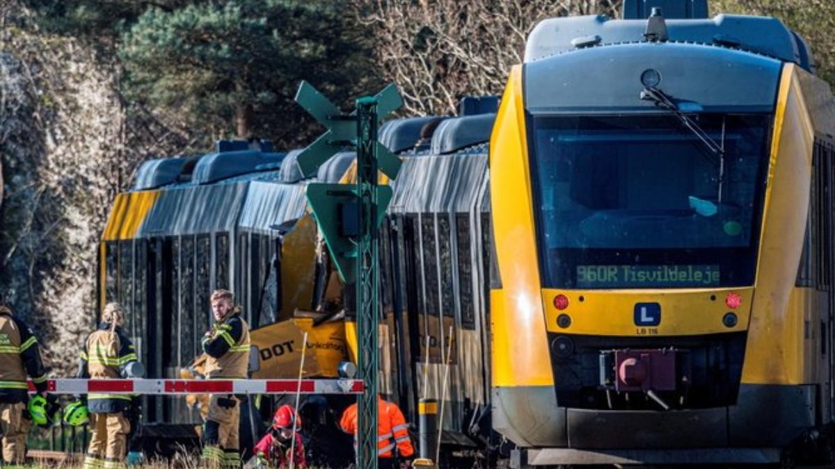 事故現場可見兩列黃灰色火車車頭嚴重毀損，丹麥緊急救援部門派遣直升機與救護車趕赴現場支援。