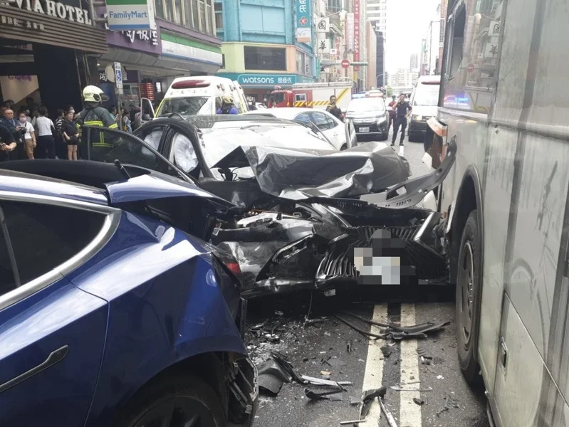 78歲邱姓老董無照駕車暴衝造成6車連撞現場，車頭全毀，場面怵目驚心。而遭撞之一的特斯拉車損嚴重，車主昨日深夜前往警局提告。（翻攝畫面）