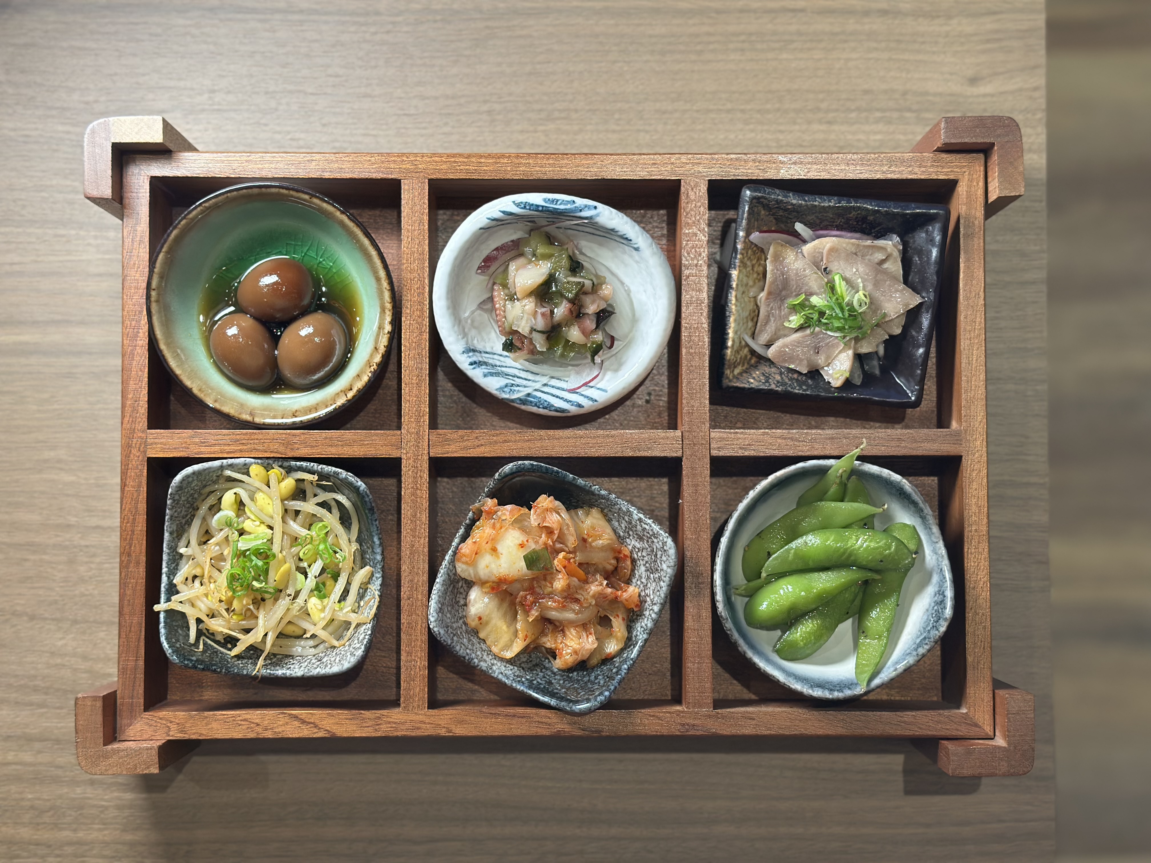 用木盒盛裝的「六宮格開胃小品」，上桌很有儀式感，搭配串燒吃，能變化味道。（300元／份）