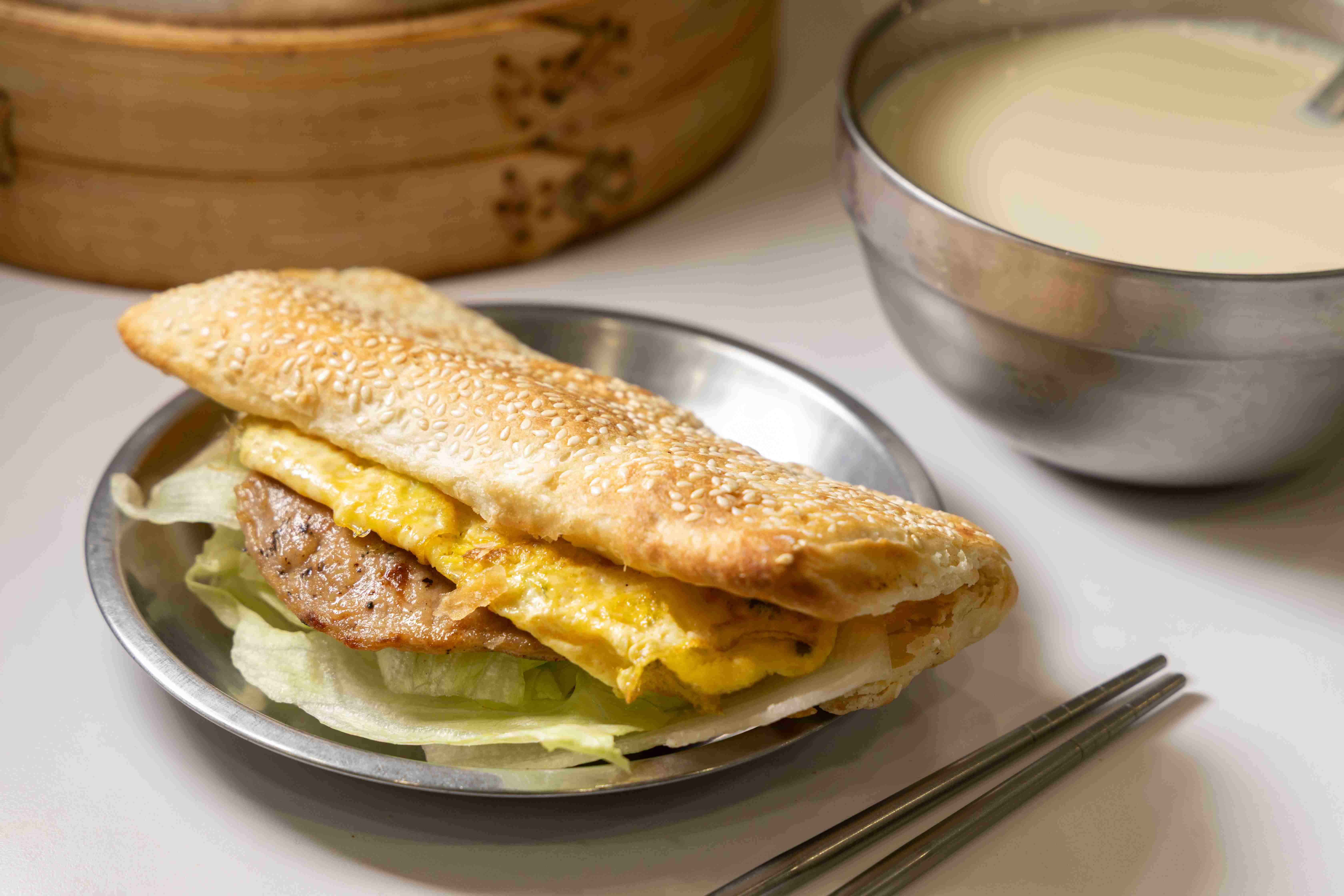 年輕客人愛點的「燒餅肉片蛋」（前，55元／份），適合搭配「熱豆漿」（後，25元／碗）。