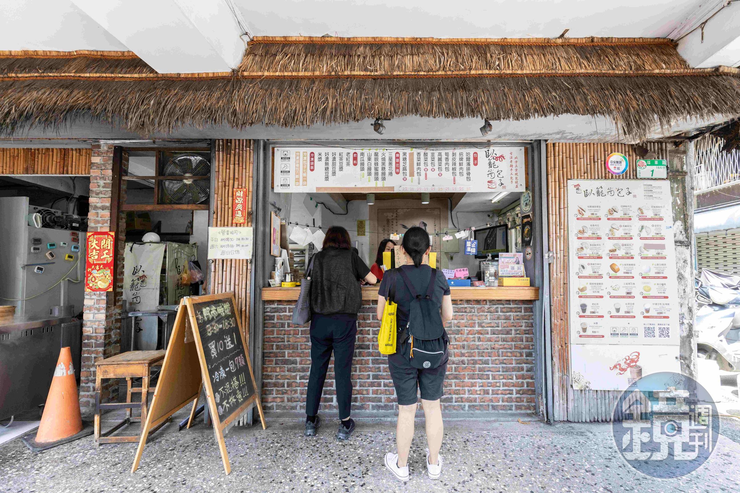 「臥籠崗包子」的店面以茅草頂裝飾，和店名相映成趣。