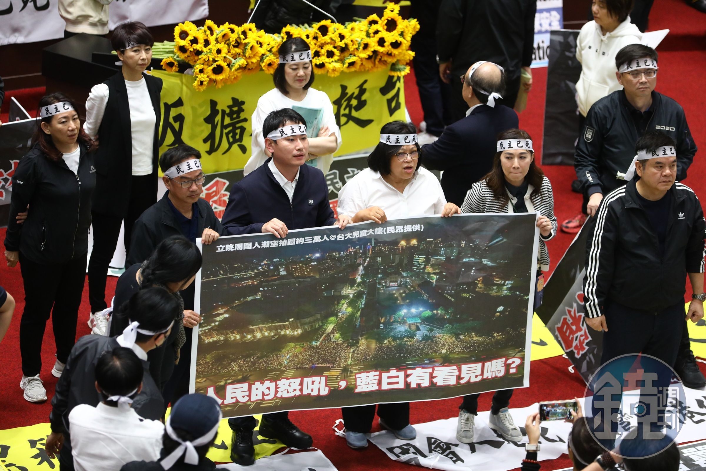 立法院內,民進黨立委們也舉起了場外人潮的海報。