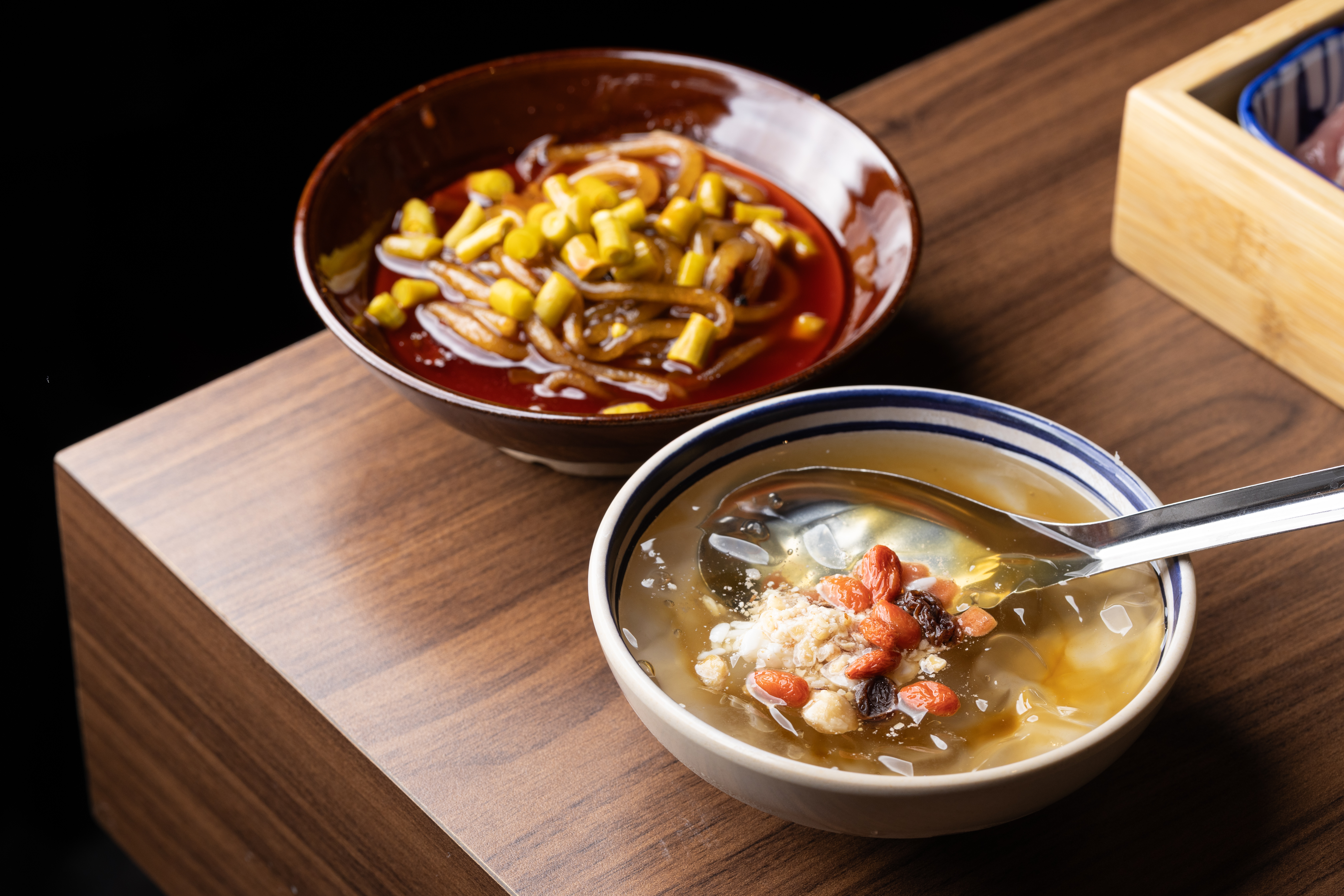 「酸辣粉」（後，100元／份）下鍋煮完再放上酸豆丁加湯，就是一碗酸辣粉；再來份搭配果乾、山楂碎與酒釀的「成都冰粉」（前，80元／碗），冰涼解辣。