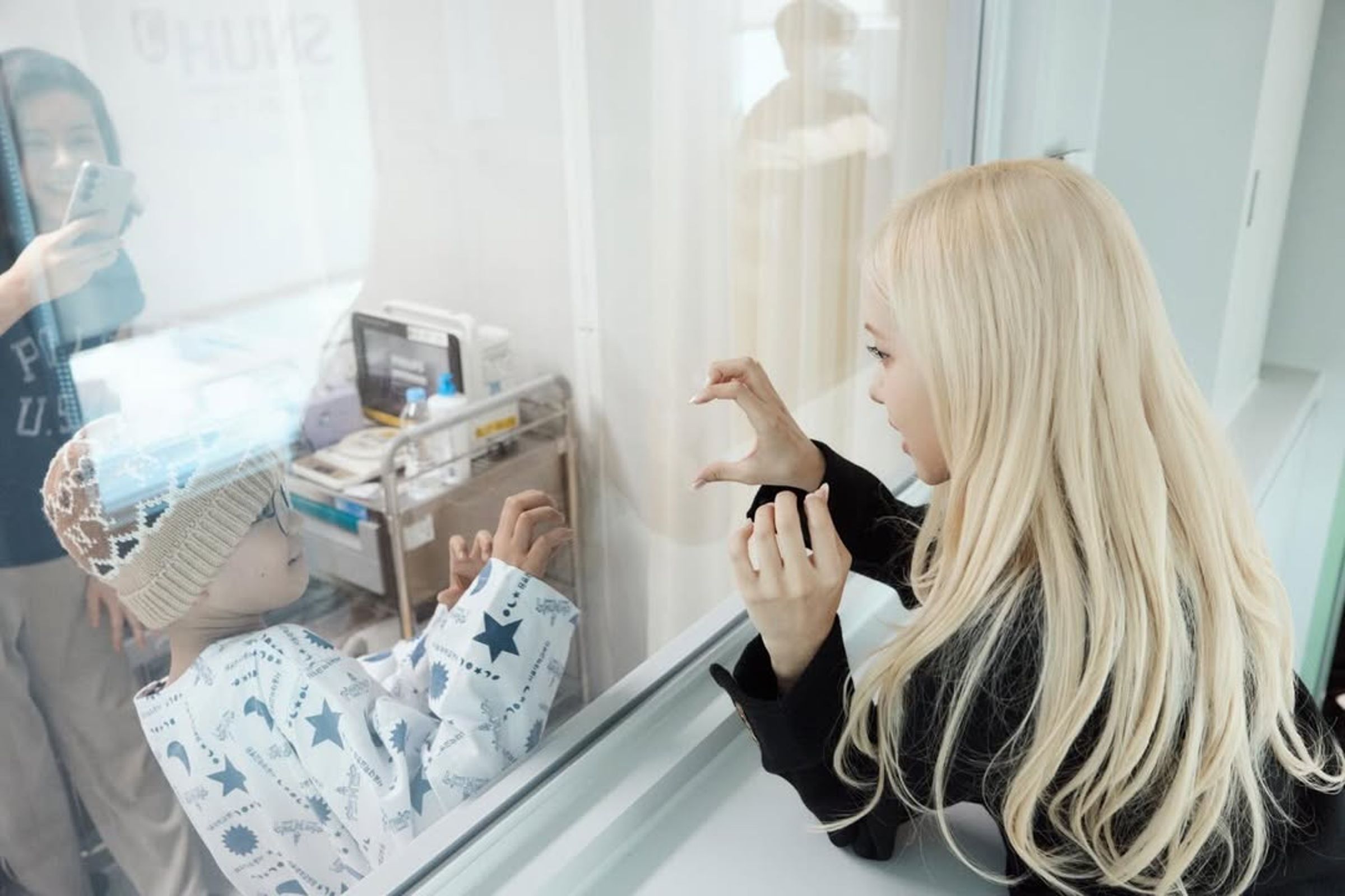 Rosé隔著玻璃,與病童一起比出愛心手勢。(翻攝roses_are_rosie IG)