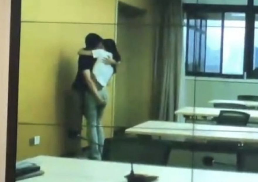 中國一對男女在會議室忘情擁吻，男方手部不安分瘋狂揉臀女方臀部，全程都被直播放送。（翻攝自微博）