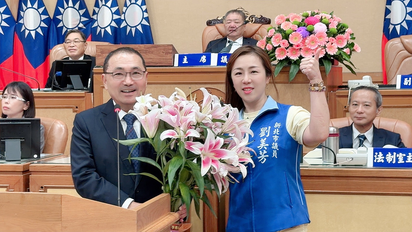 劉美芳準備一束百合花送給侯友宜作為「畢業賀禮」,期待市府把AI教育成果制度化傳承下去,讓孩子學會運用科技將想法創造出來。(劉美芳服務處提供)
