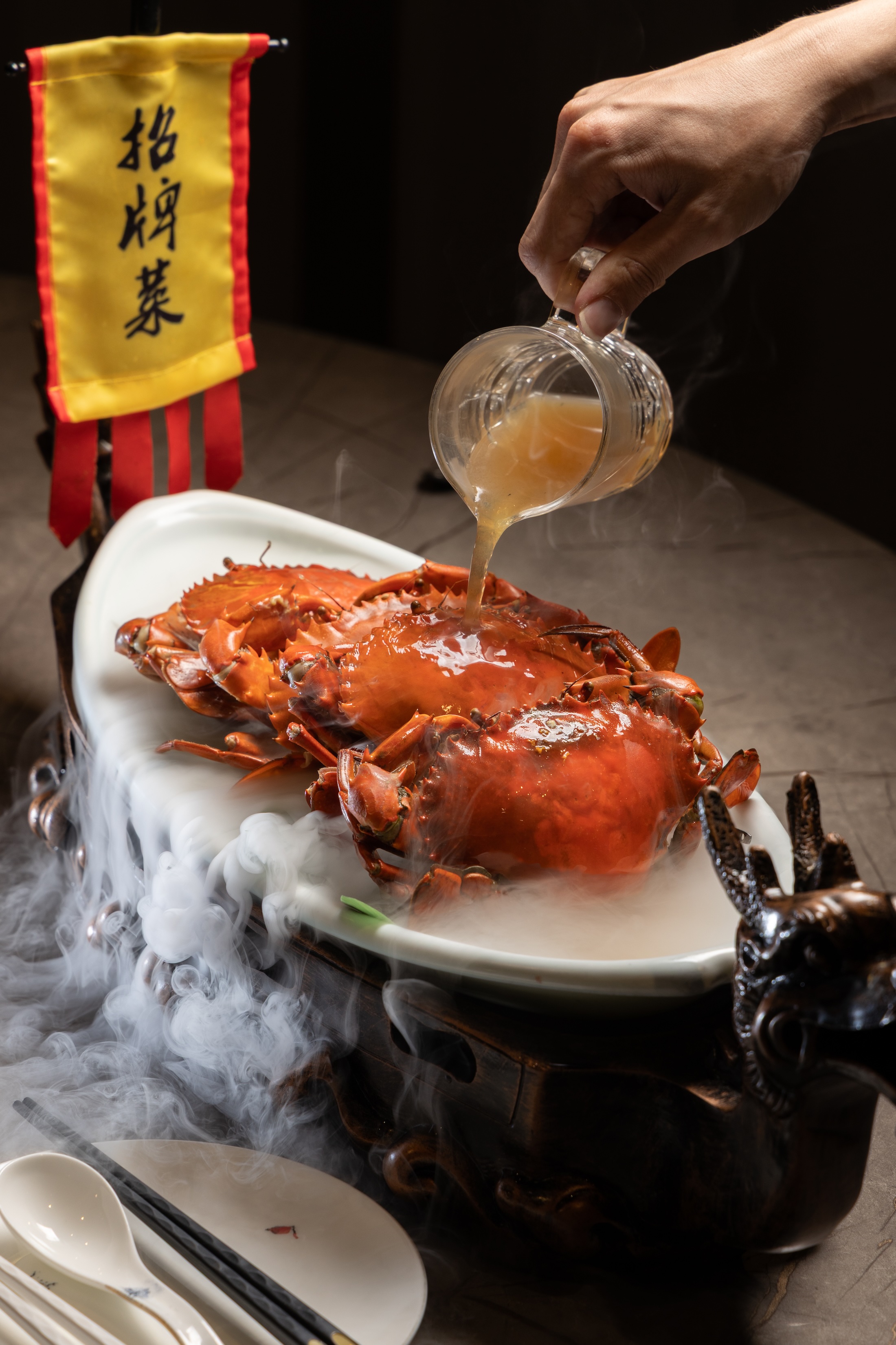 「陳年紹興清蒸紅蟳」上桌時會淋入紹興酒,乾冰白霧隨即升起,酒香與視覺效果為餐桌增添儀式感。