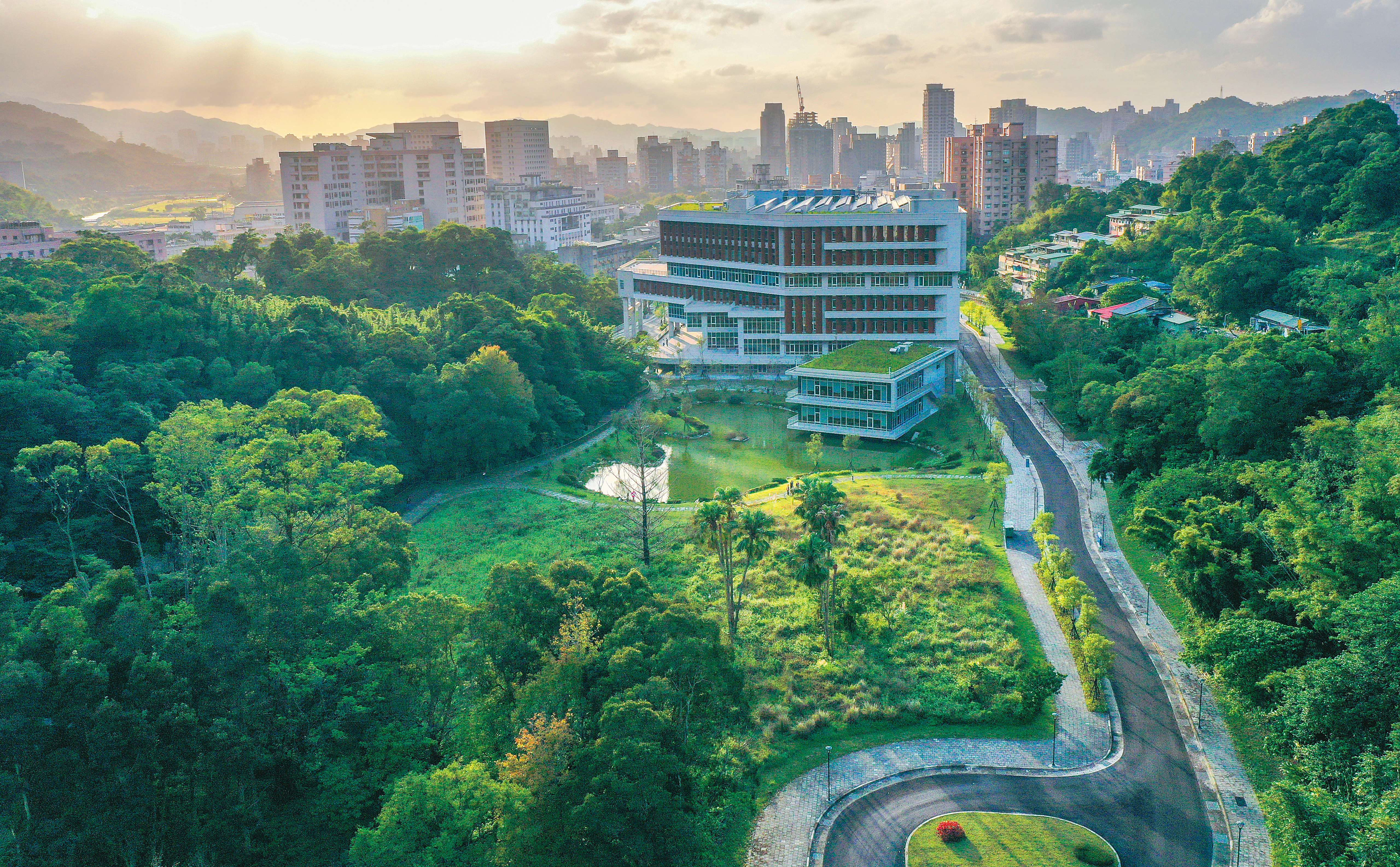 達賢圖書館與湖光山色、綠意草坪交織成靜謐天地。（圖／國立政治大學）