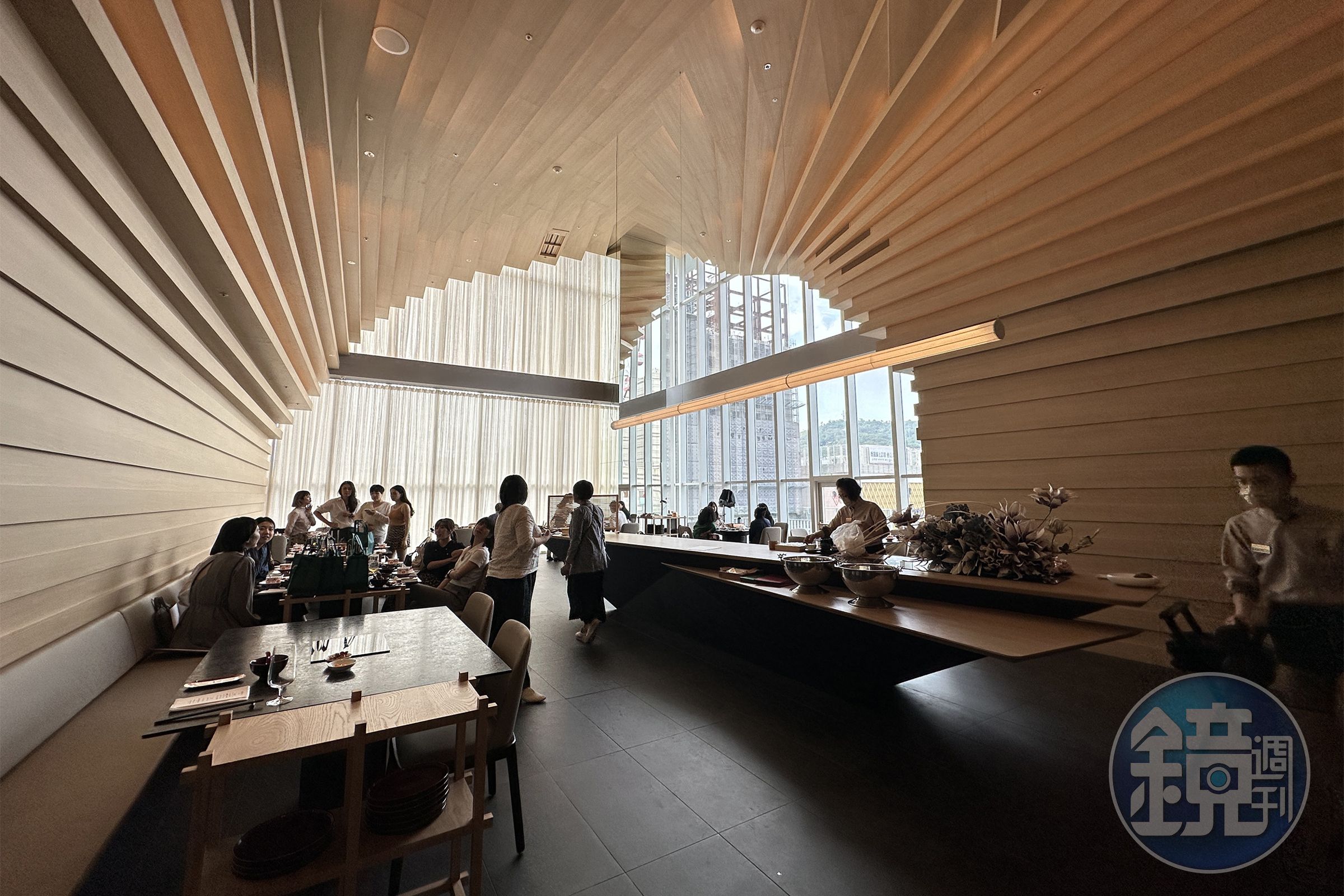 餐廳空間以大量木質建材為主軸，營造有如置身巨大天然海蝕洞中的包覆感。（童心怡攝）
