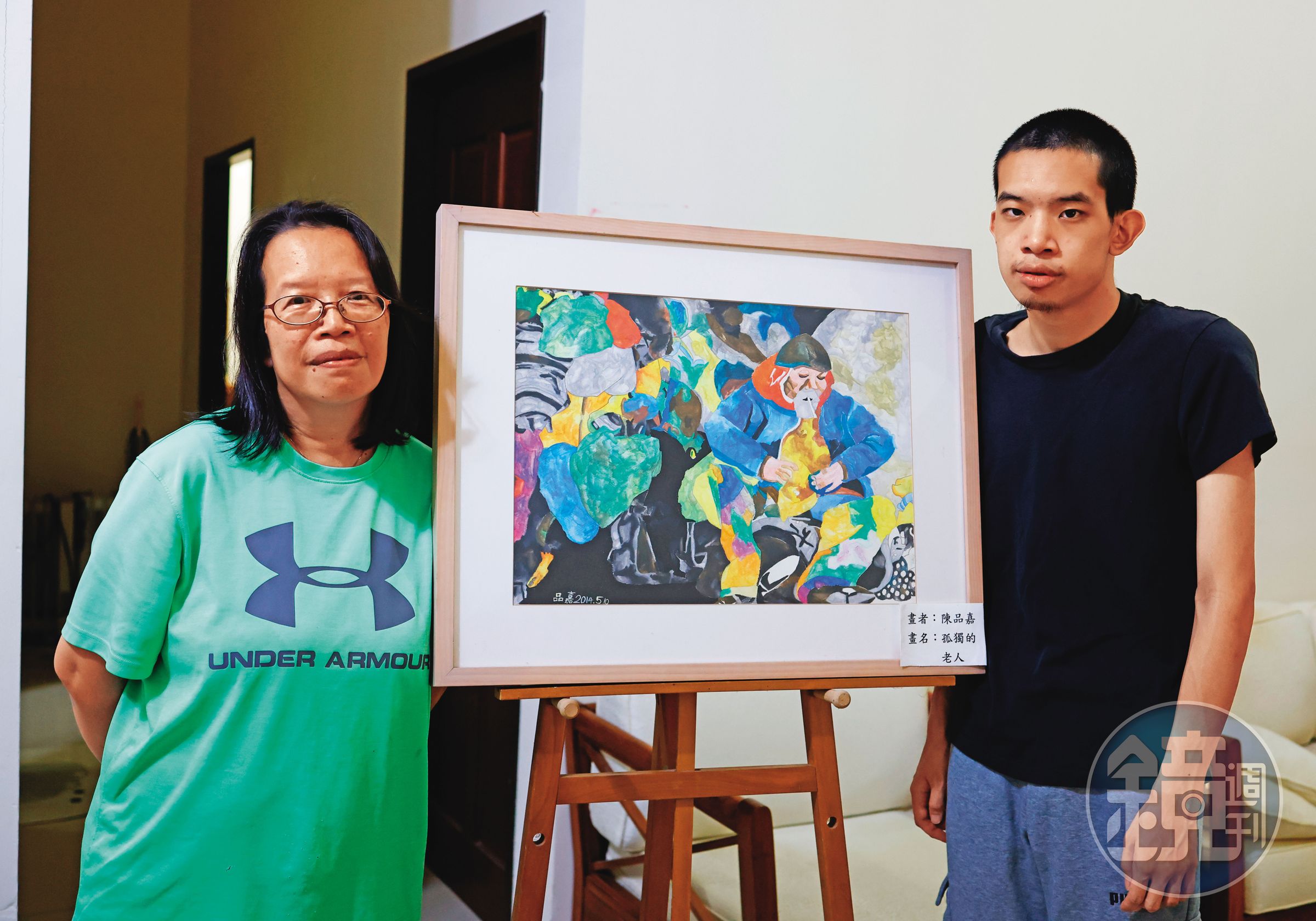 董明芬與兒子,中間為兒子所繪作品。