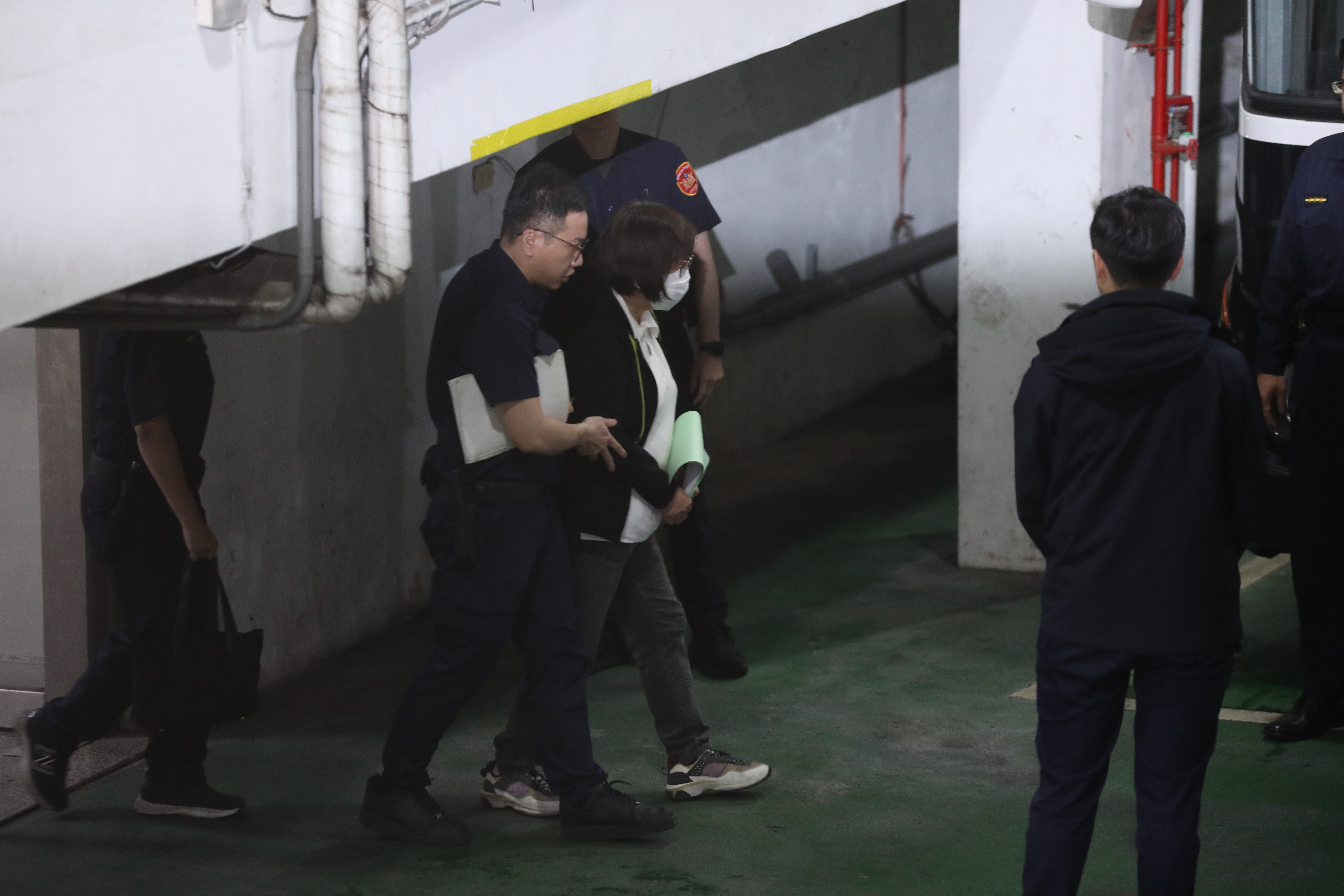 台北市黨部主委黃呂錦茹涉死亡連署遭改裁定羈押禁見，戴手銬上囚車。