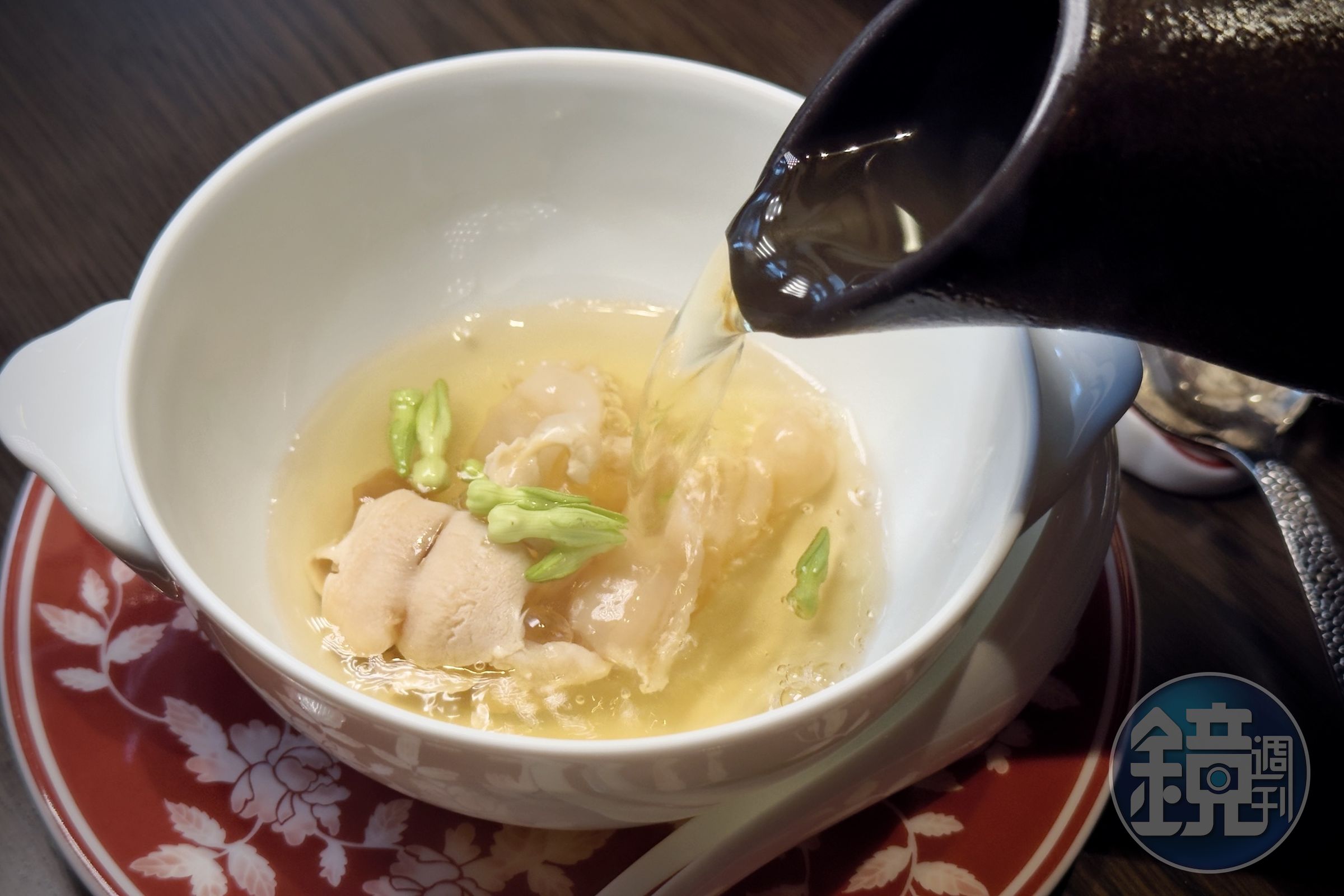 「衝浪象拔蚌吊湯」將象拔蚌切成薄片，現場淋入慢燉三小時的清鮮高湯，瞬間釋放極致鮮甜。
