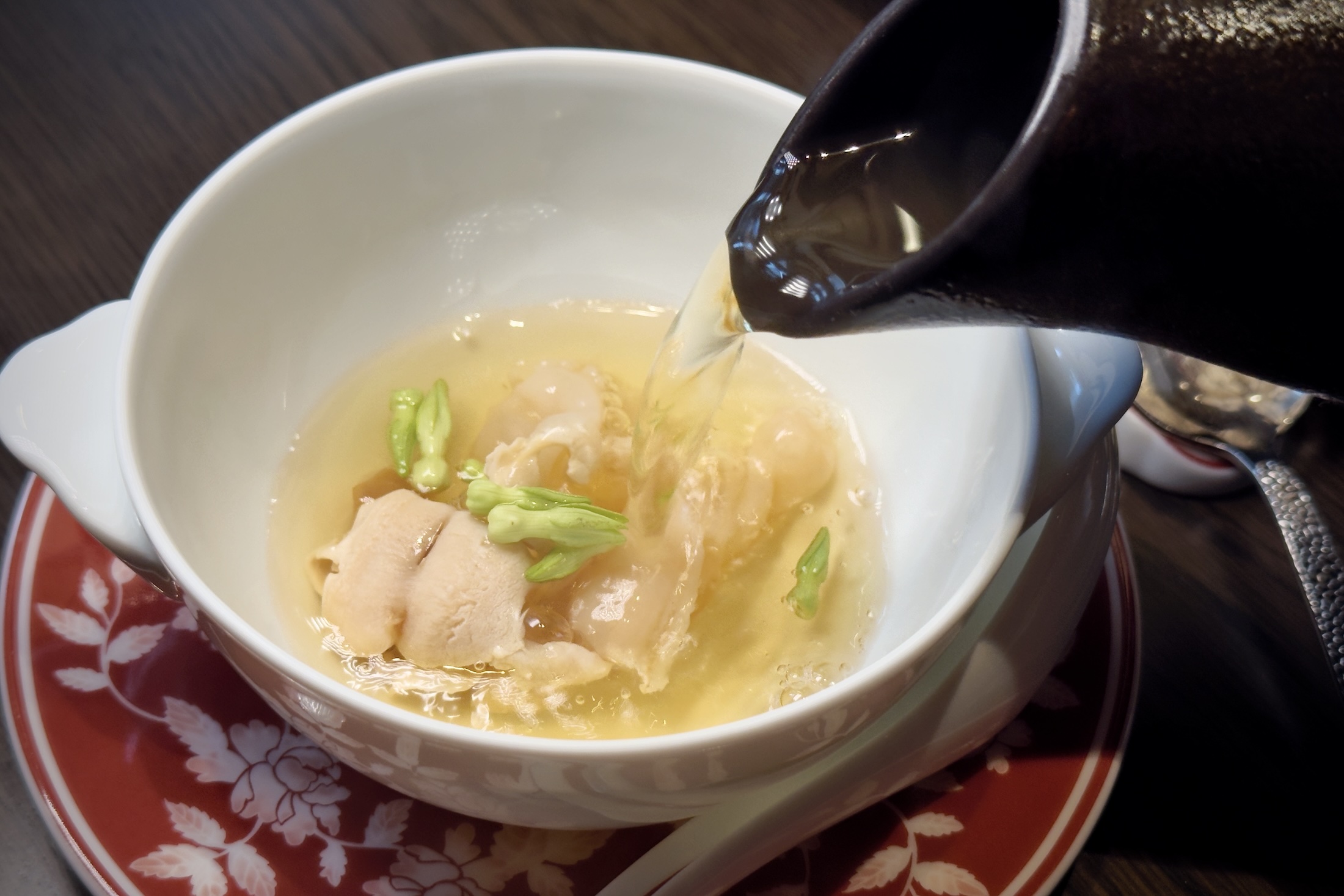 「衝浪象拔蚌吊湯」將象拔蚌切成薄片,現場淋入慢燉三小時的清鮮高湯,瞬間釋放極致鮮甜。